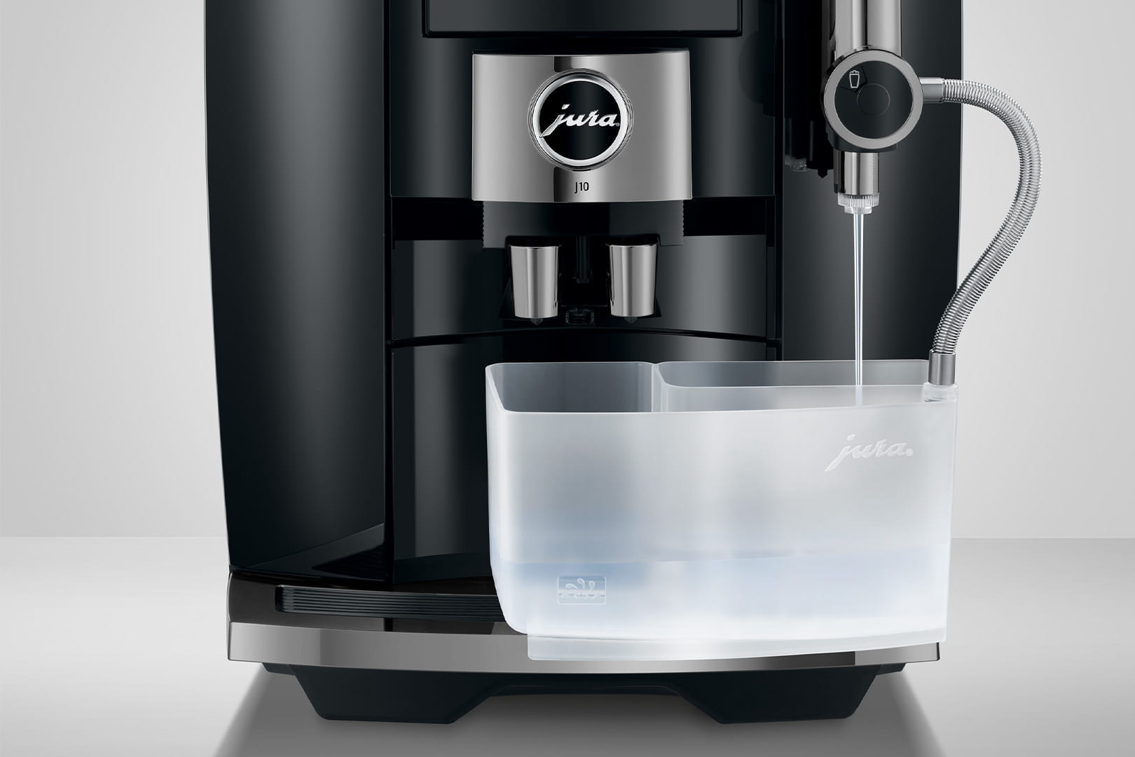 Macchina per espresso nera e argento. L'erogatore d'acqua è attivo in un contenitore trasparente.