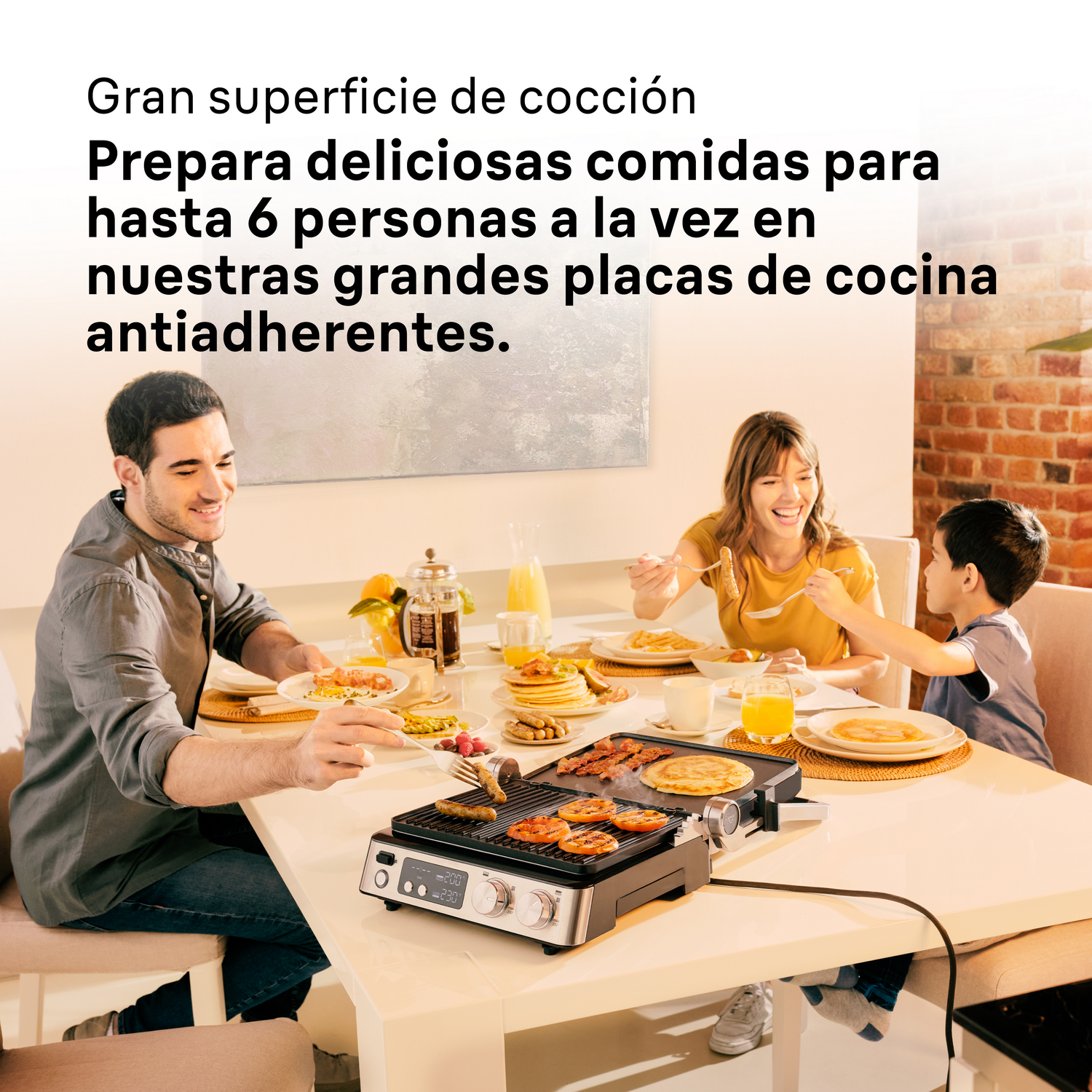 Una familia disfrutando de una comida cocinada en una parrilla de mesa, en interiores.