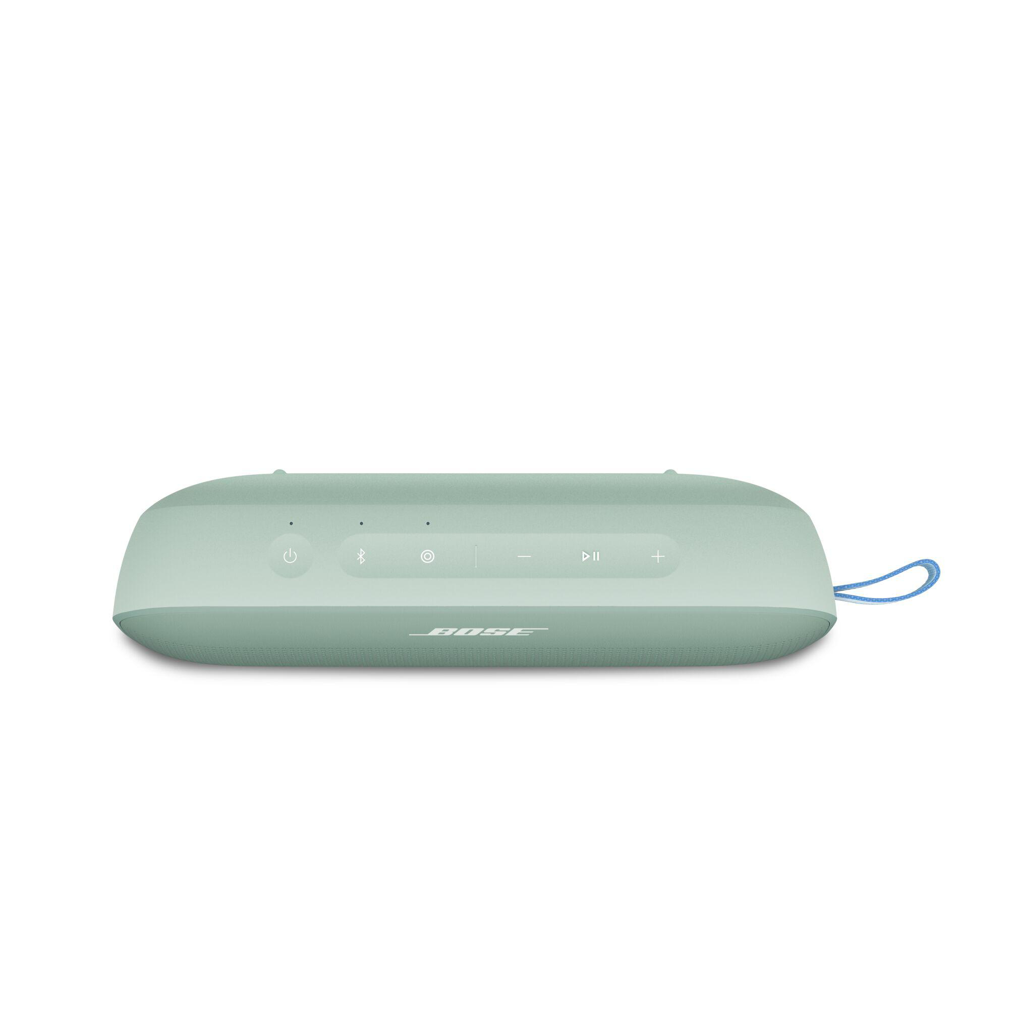 Ein teal-farbener, oval geformter tragbarer Lautsprecher mit Knöpfen und blauer Schlaufe auf weißem Grund.