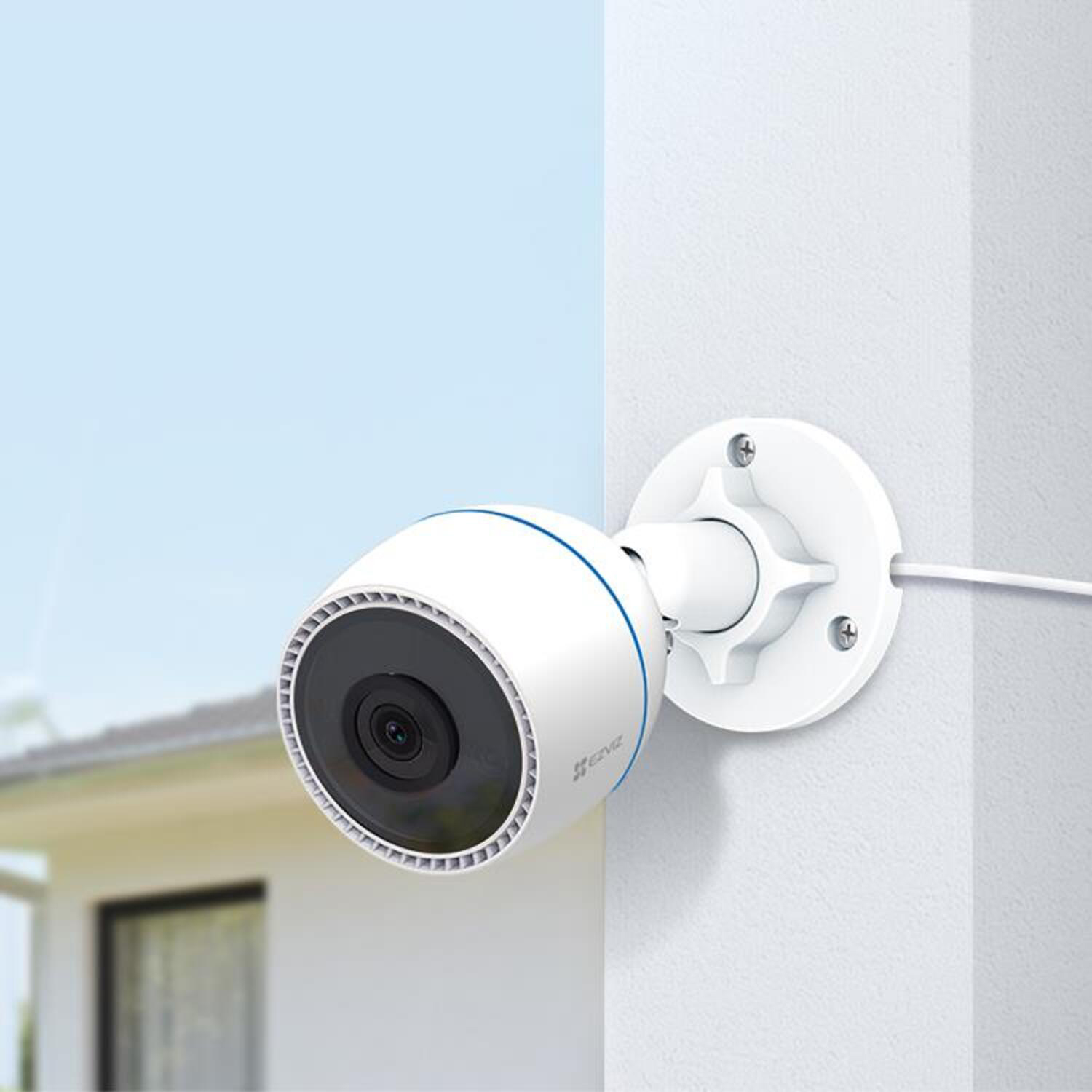 Una telecamera di sicurezza bianca montata su un muro, angolata verso lo spettatore, con un accento blu.