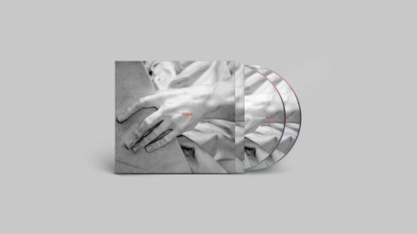 Albumhoes: Hand op een lichaam, wit en zwart. Twee cd's zijn zichtbaar.