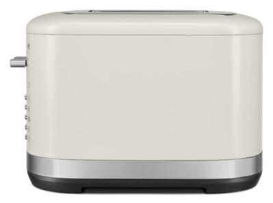 Ein cremefarbener Toaster mit silbernem Sockel und Knöpfen.