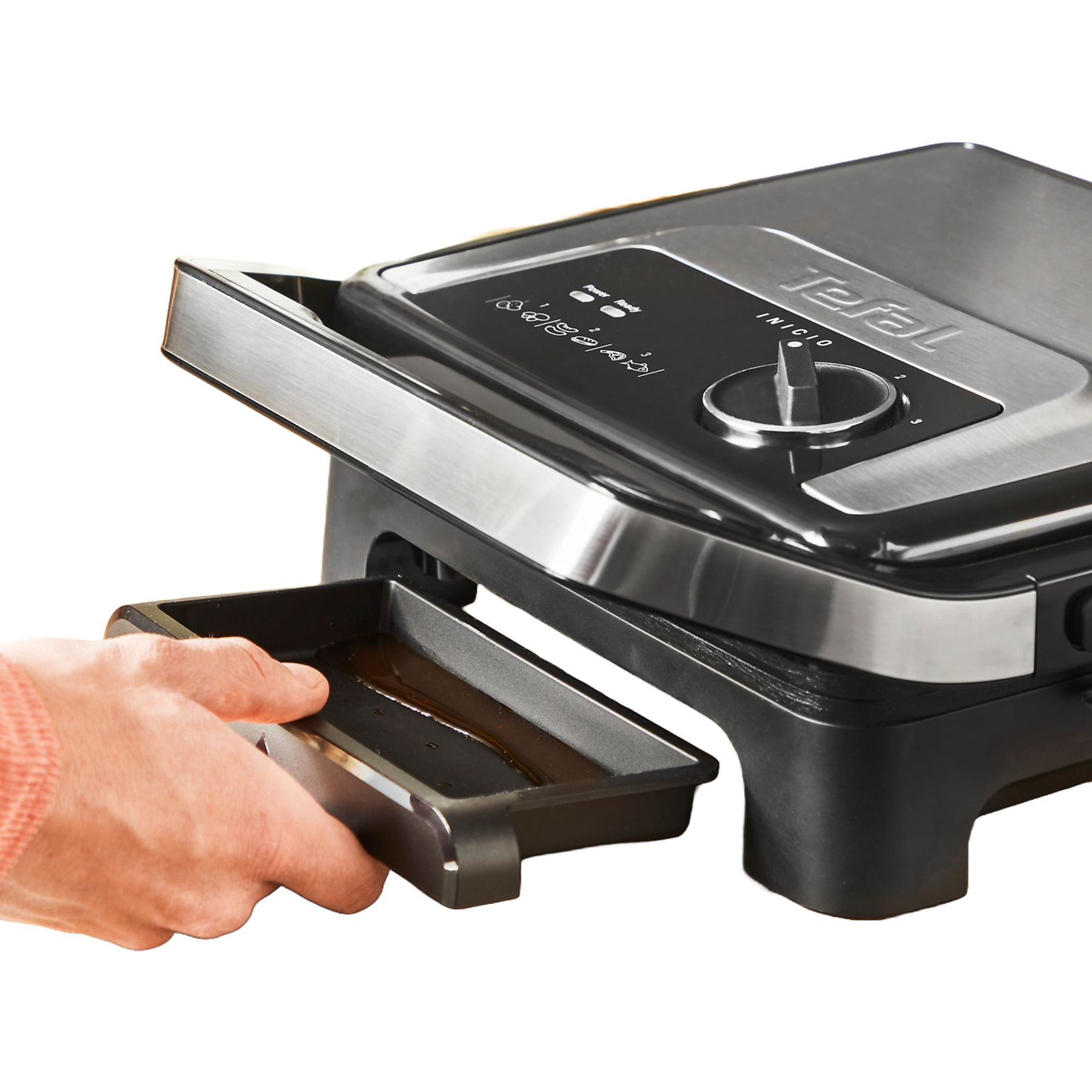 Kéz Tefal készüléket használ. Fekete és ezüst, a tálca kihúzva.