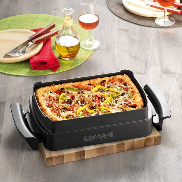 Pizza egy fekete OptiGrillben egy fa deszkán.