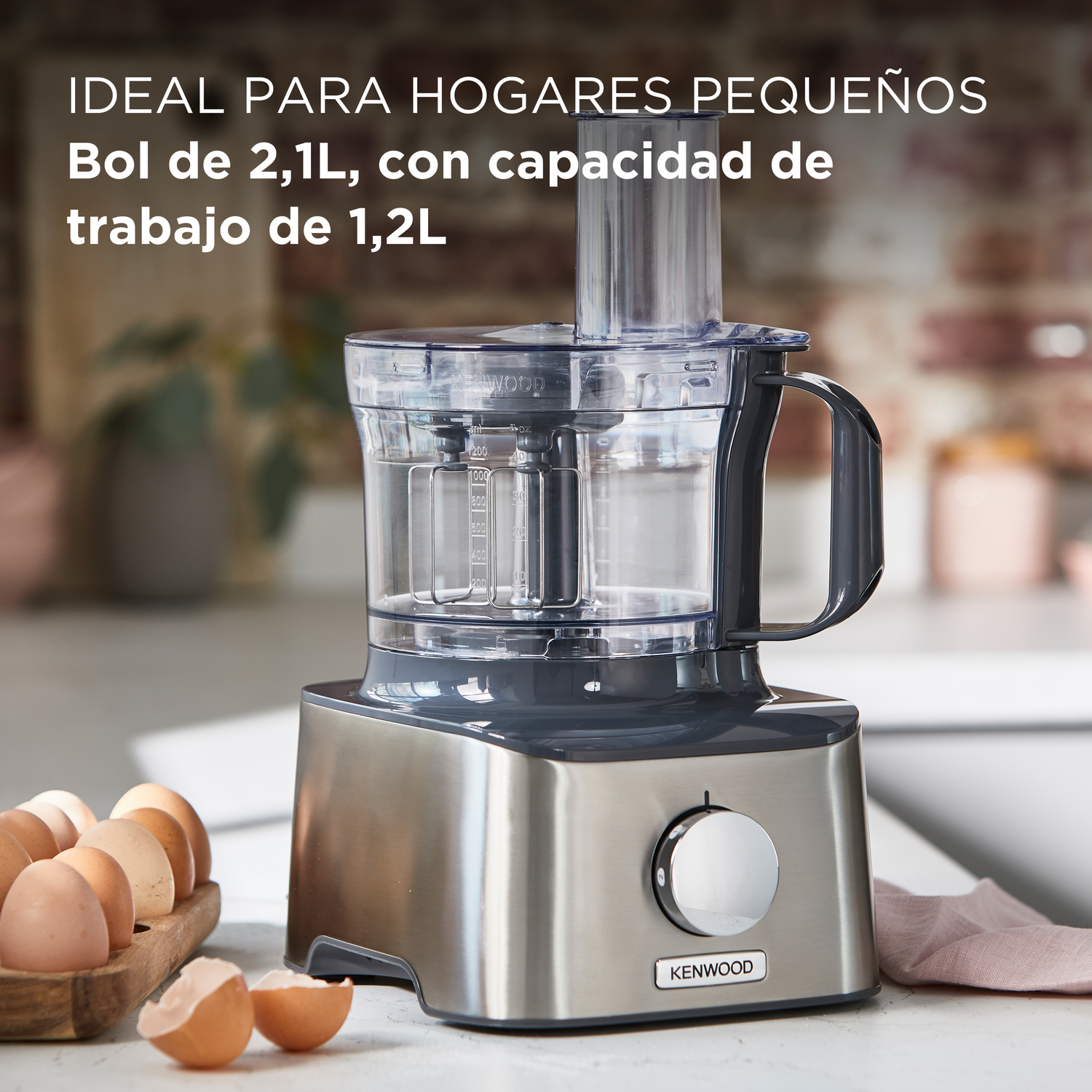 Procesador de alimentos con varios accesorios y base plateada.