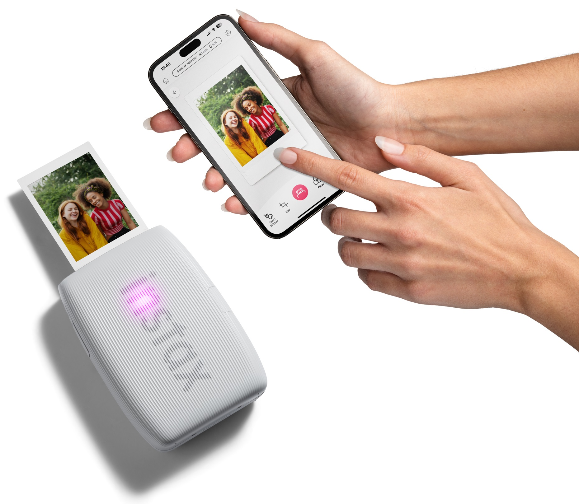 Osoba drukująca zdjęcie z telefonu za pomocą białej drukarki Instax. Telefon pokazuje zdjęcie.