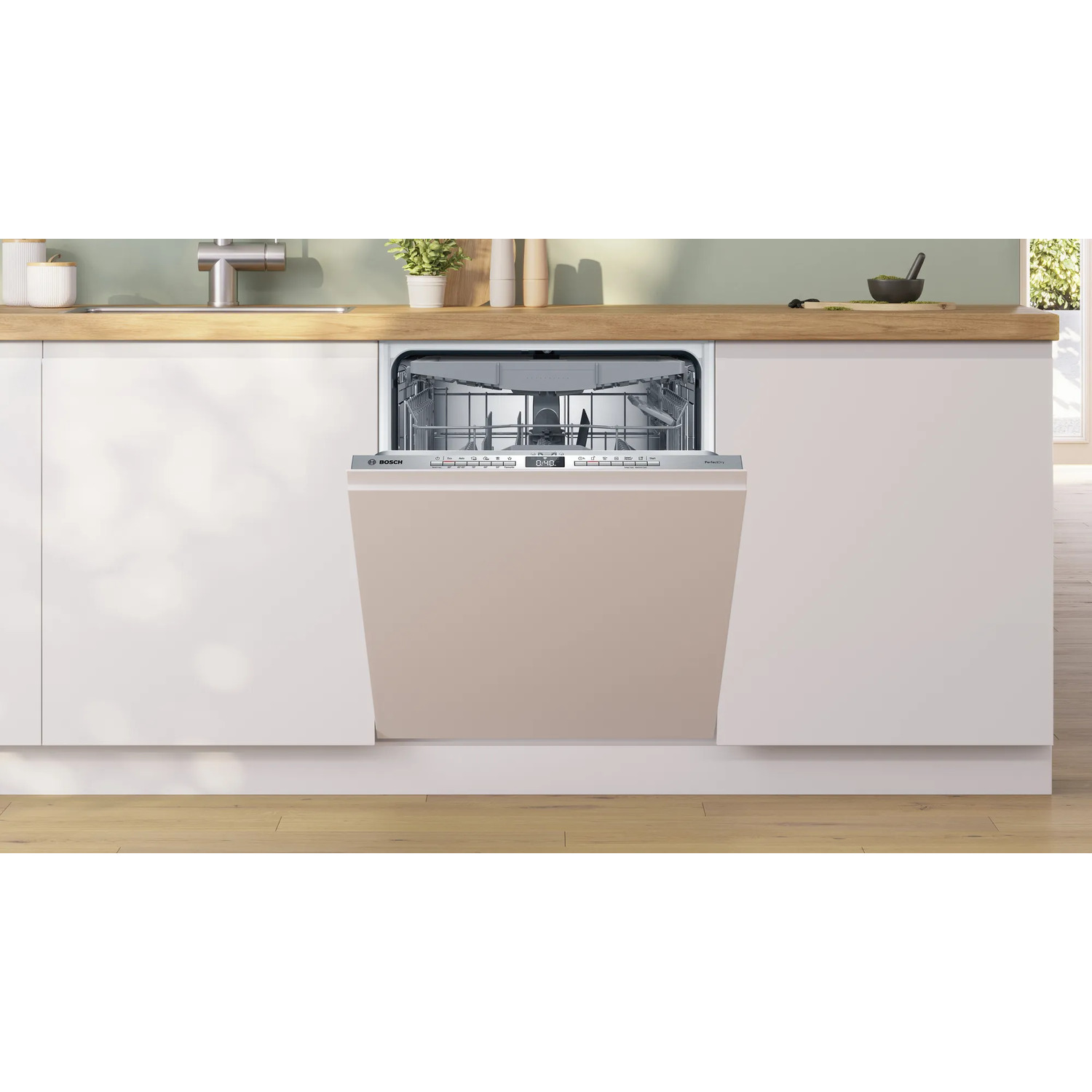 Een beige vaatwasser is open in een keuken. Witte kasten aan weerszijden, met een houten aanrecht.