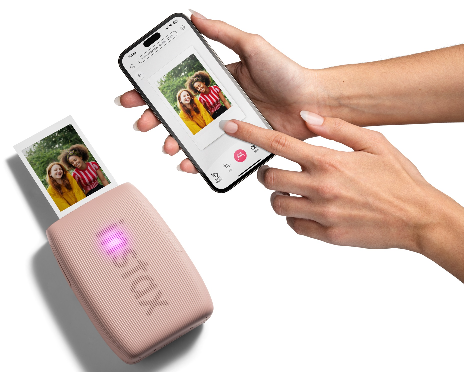 Osoba drukuje zdjęcie ze smartfona za pomocą różowej drukarki fotograficznej.