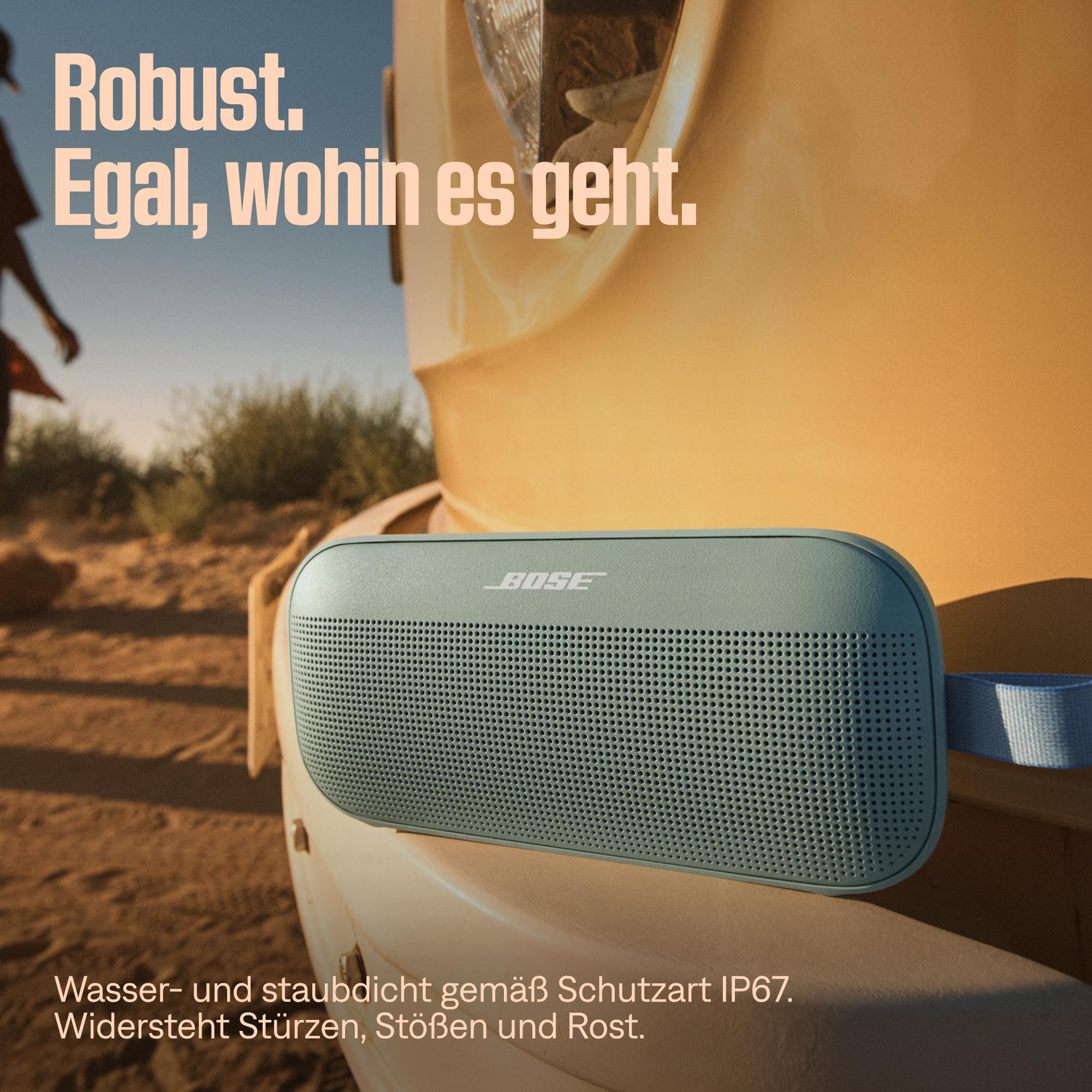 Bose-Lautsprecher auf einem gelben Fahrzeug mit Text: "Robust. Egal, wohin es geht."