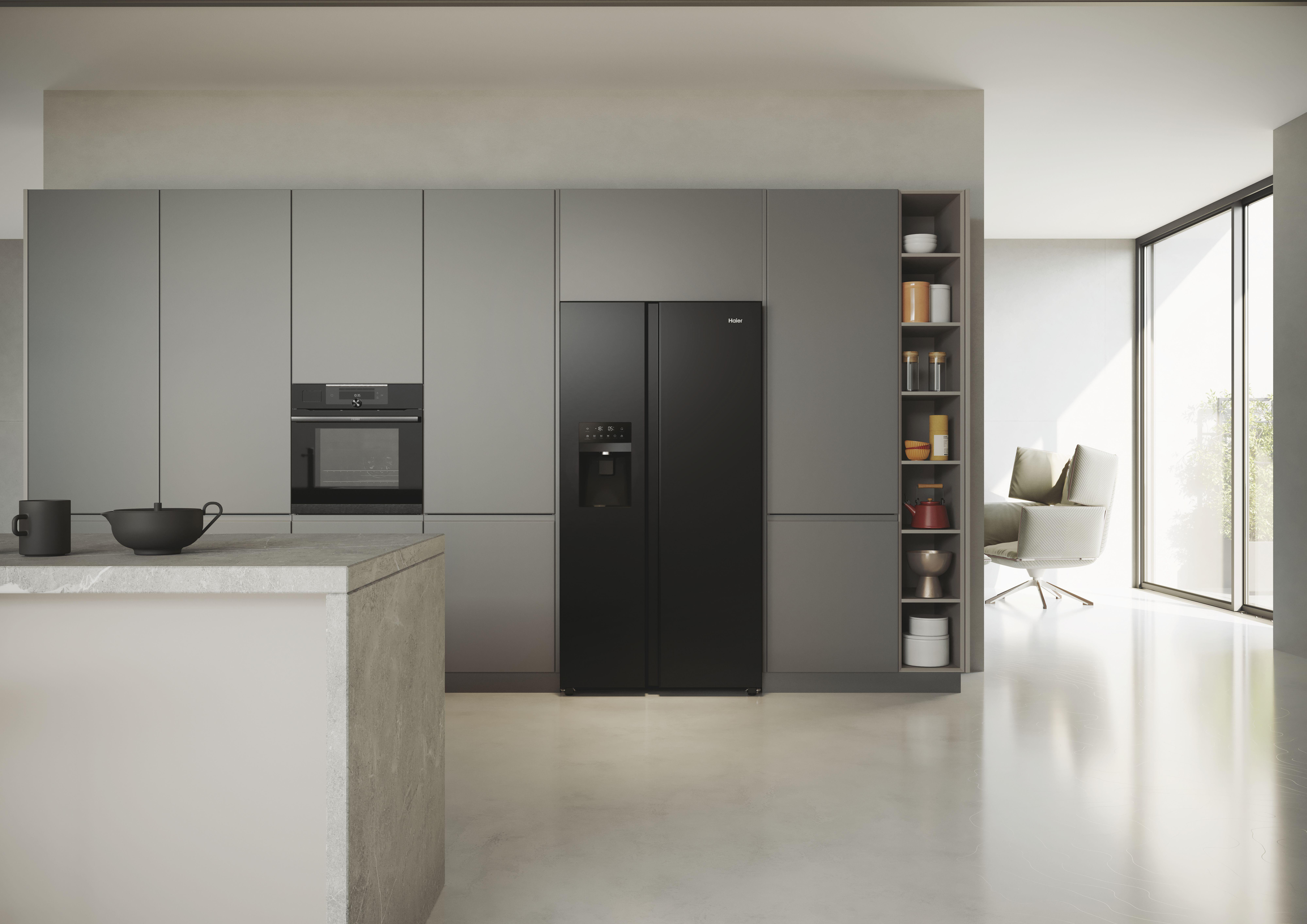 Küche mit grauen Schränken und einem schwarzen Kühlschrank. Eine weiße Insel im Vordergrund.