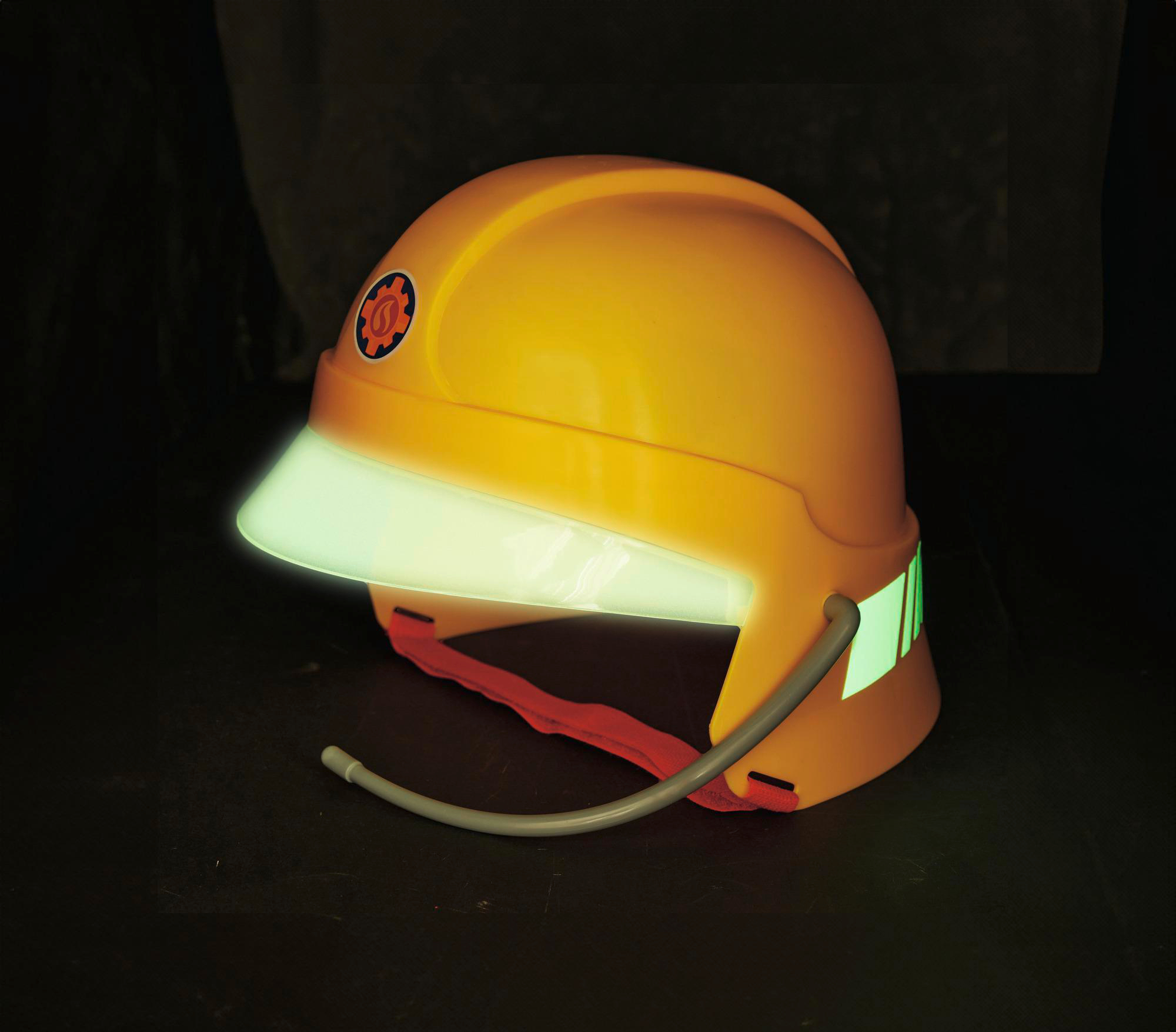 Gelber Feuerwehrhelm. Ein Visier leuchtet grün. Dunkler Hintergrund.