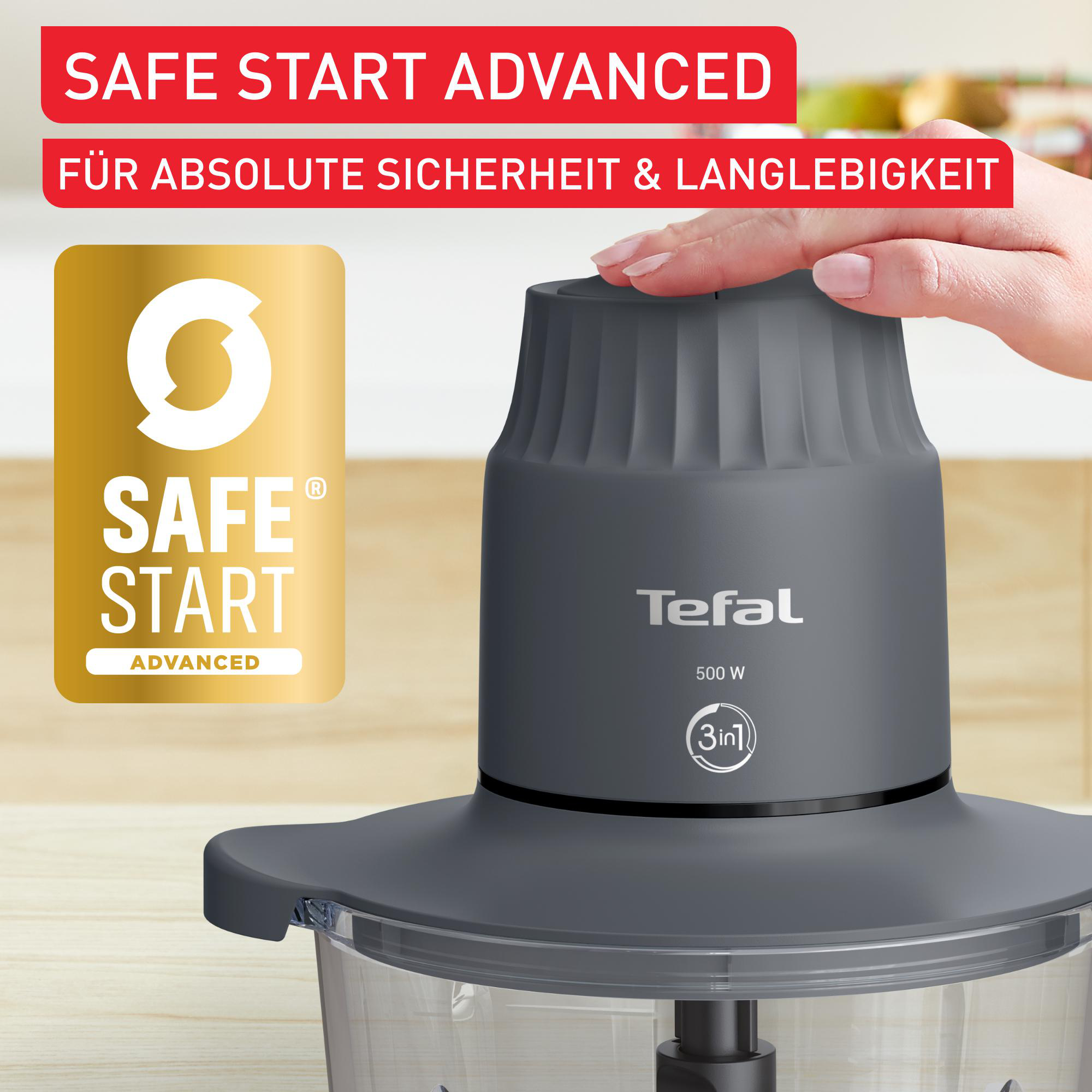 Tefal-Küchenmaschine mit grauem Gehäuse und transparentem Behälter. Safe Start Logo und Text sichtbar.