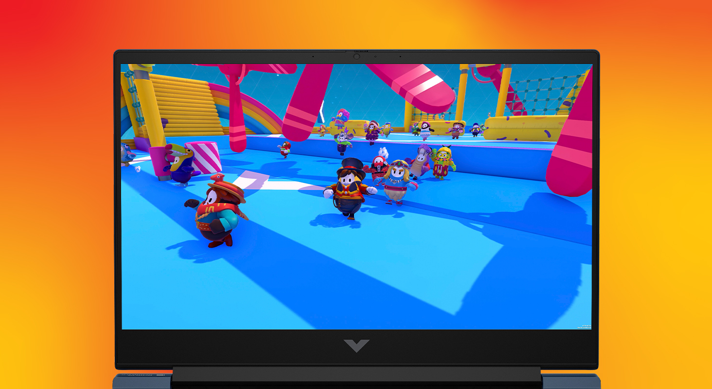 Un portátil muestra una escena de videojuego con varios personajes corriendo en una colorida carrera de obstáculos.