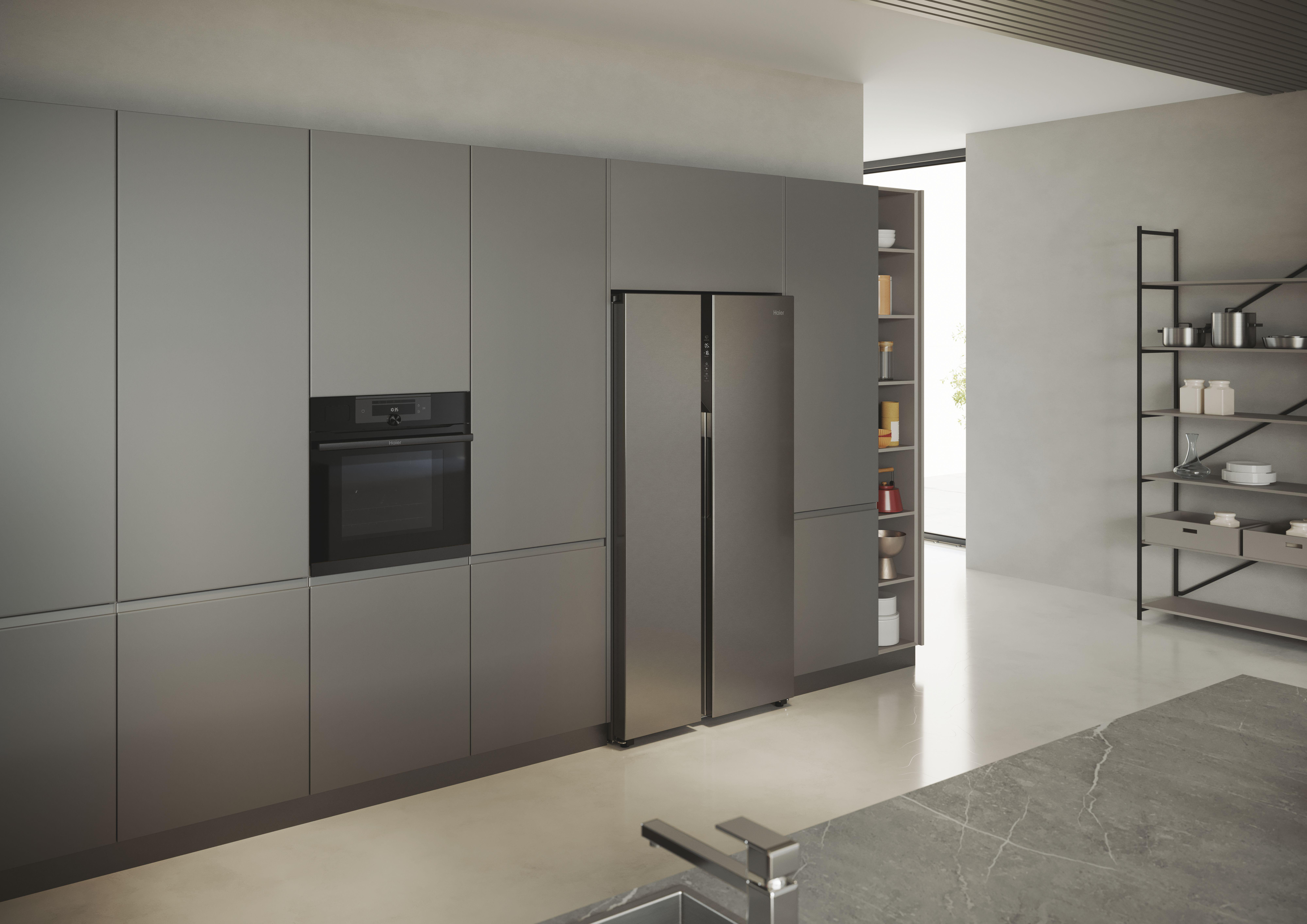 Küche mit grauen Schränken, Backofen, Side-by-Side-Kühlschrank und Marmor-Arbeitsplatte.