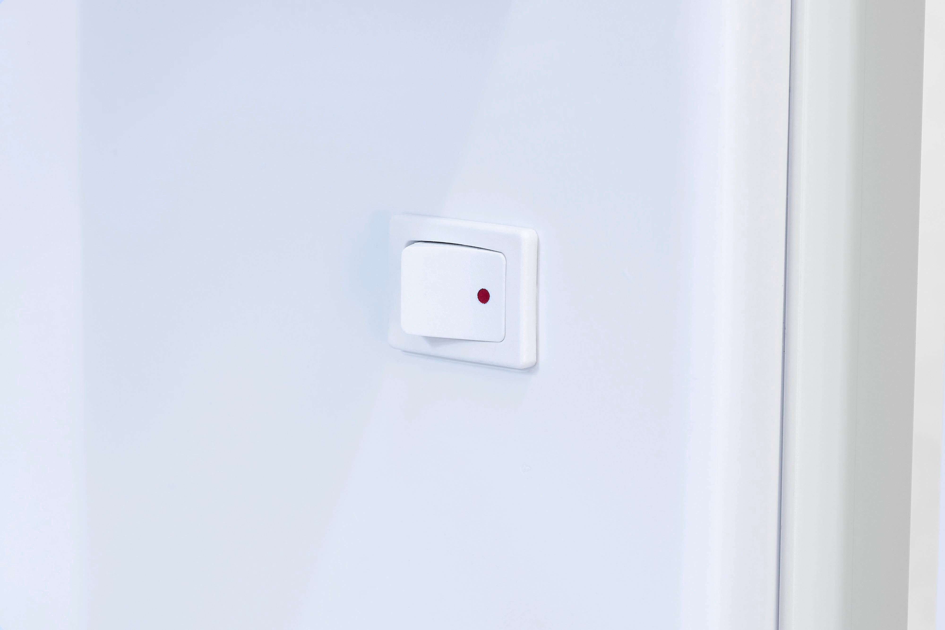 Ein weißer Lichtschalter mit einem roten Punkt an einer weißen Wand.