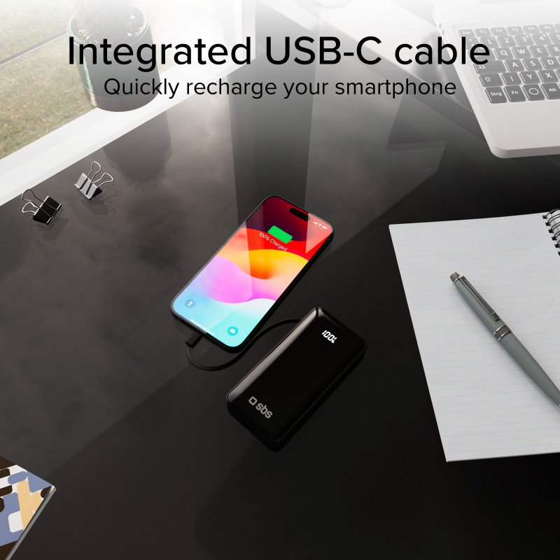 Smartfon ładujący się z power banku, z akcesoriami biurowymi.