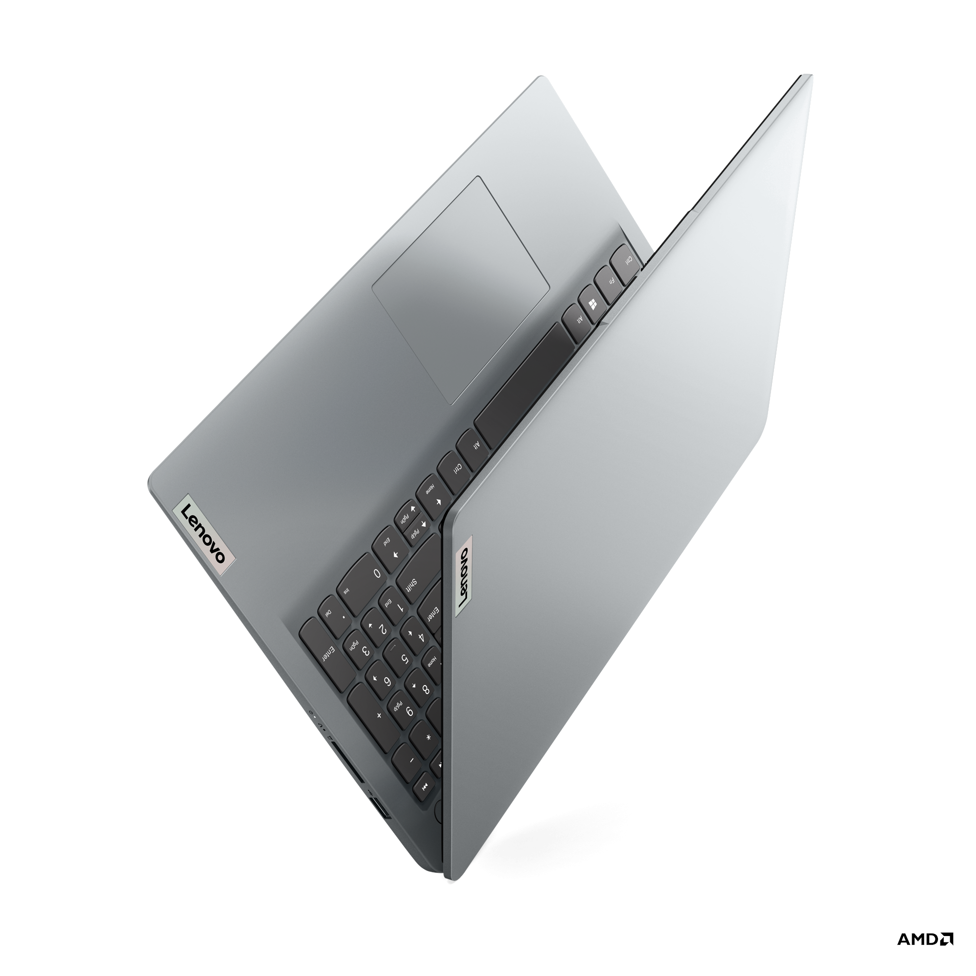 Gümüş dizüstü açık, klavye görünür, kapakta Lenovo logosu. Siyah tuşlar, dokunmatik yüzey.