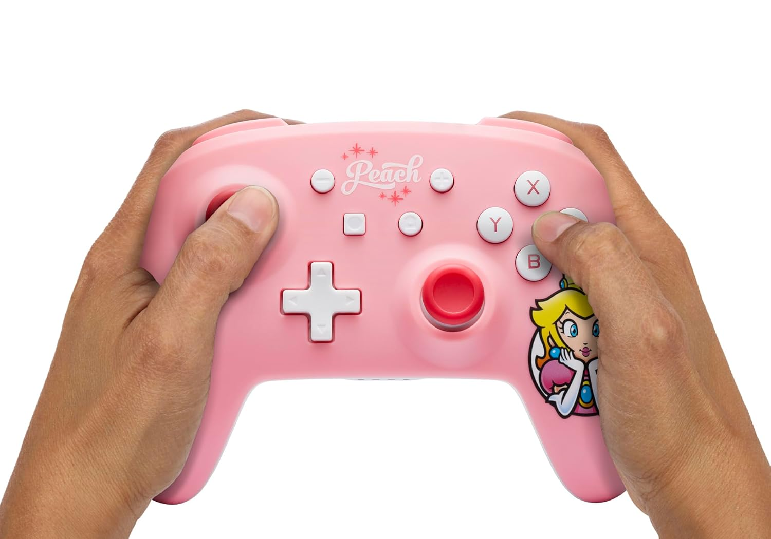 Mani che tengono un controller Nintendo rosa a tema Peach.