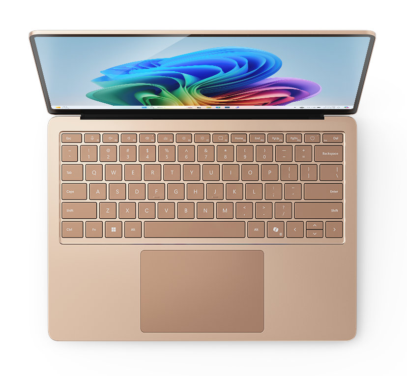 Złoty laptop z kolorowym wyświetlaczem, otwarty na białej powierzchni.
