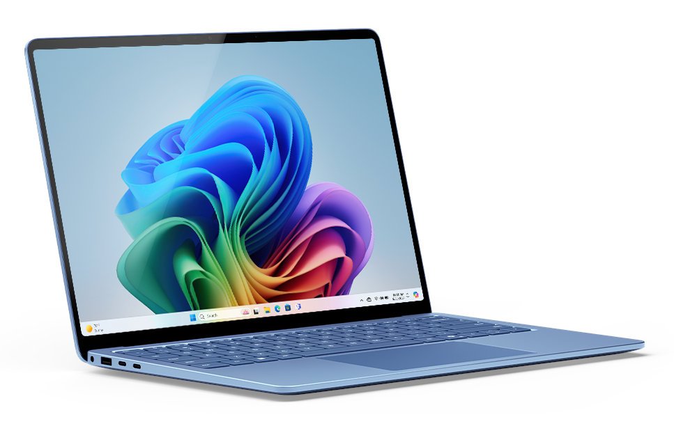 Otwarty niebieski laptop, wyświetlający kolorową, abstrakcyjną tapetę w kwiaty.