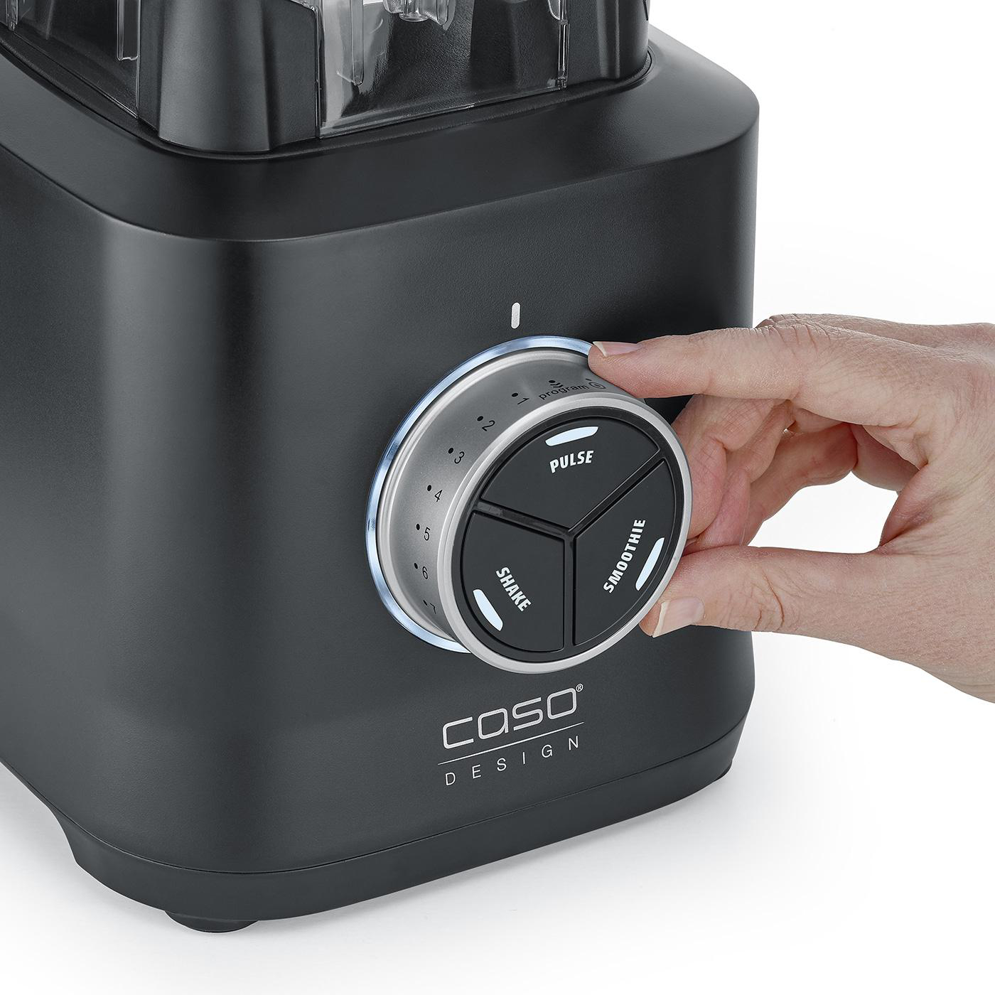 Eine Hand dreht den Drehregler eines schwarzen Mixers mit Einstellungen für Puls, Smoothie und Shake. Die Marke COSO DESIGN ist sichtbar.