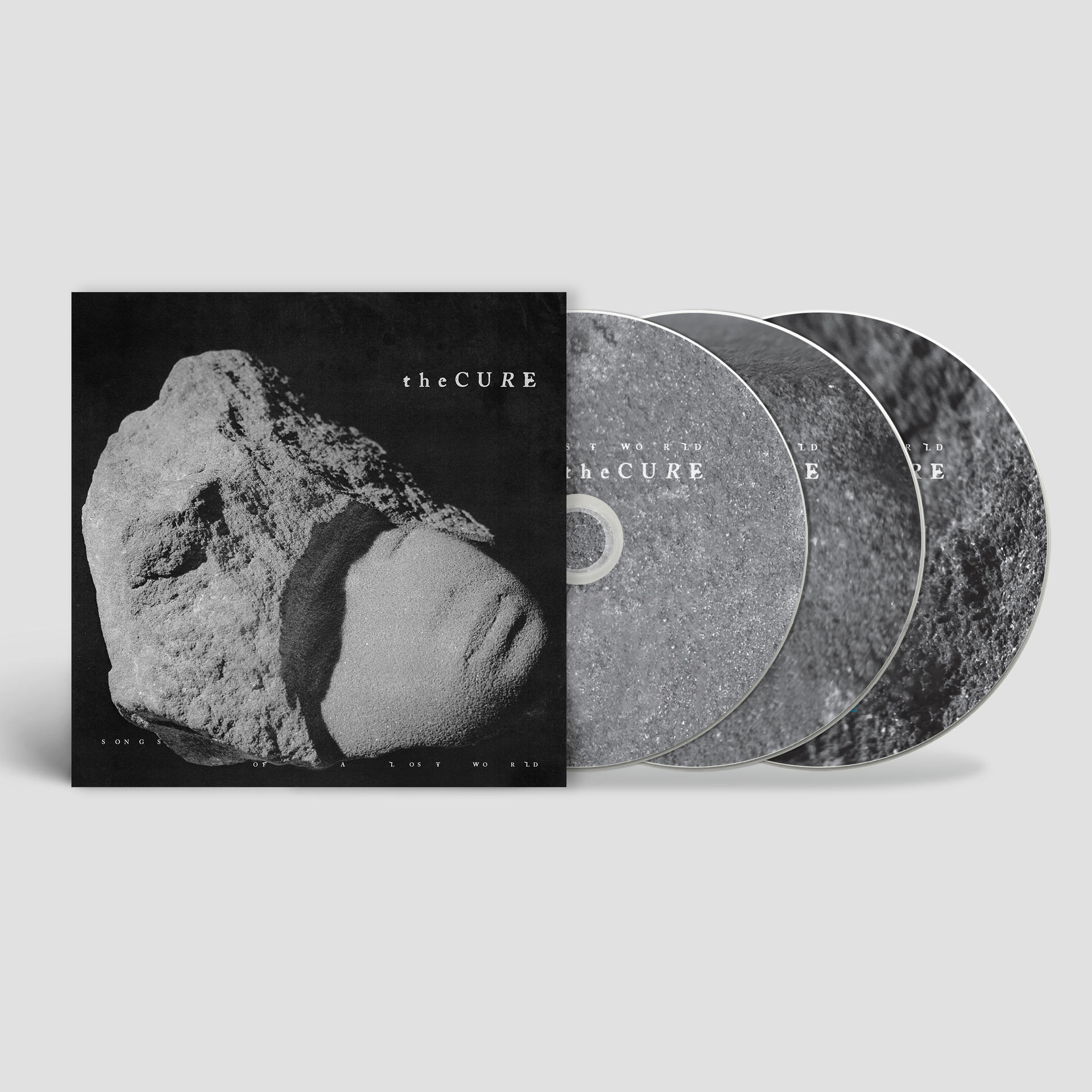 Das Album 'Songs of a Lost World' von The Cure mit CDs. Schwarz-Weiß, ein Felsen auf dem Cover.