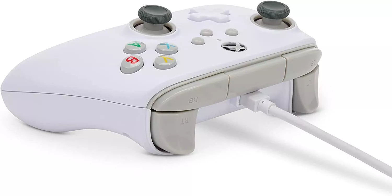 Gri vurgulara ve bağlı bir şarj kablosuna sahip beyaz Xbox denetleyicisi.