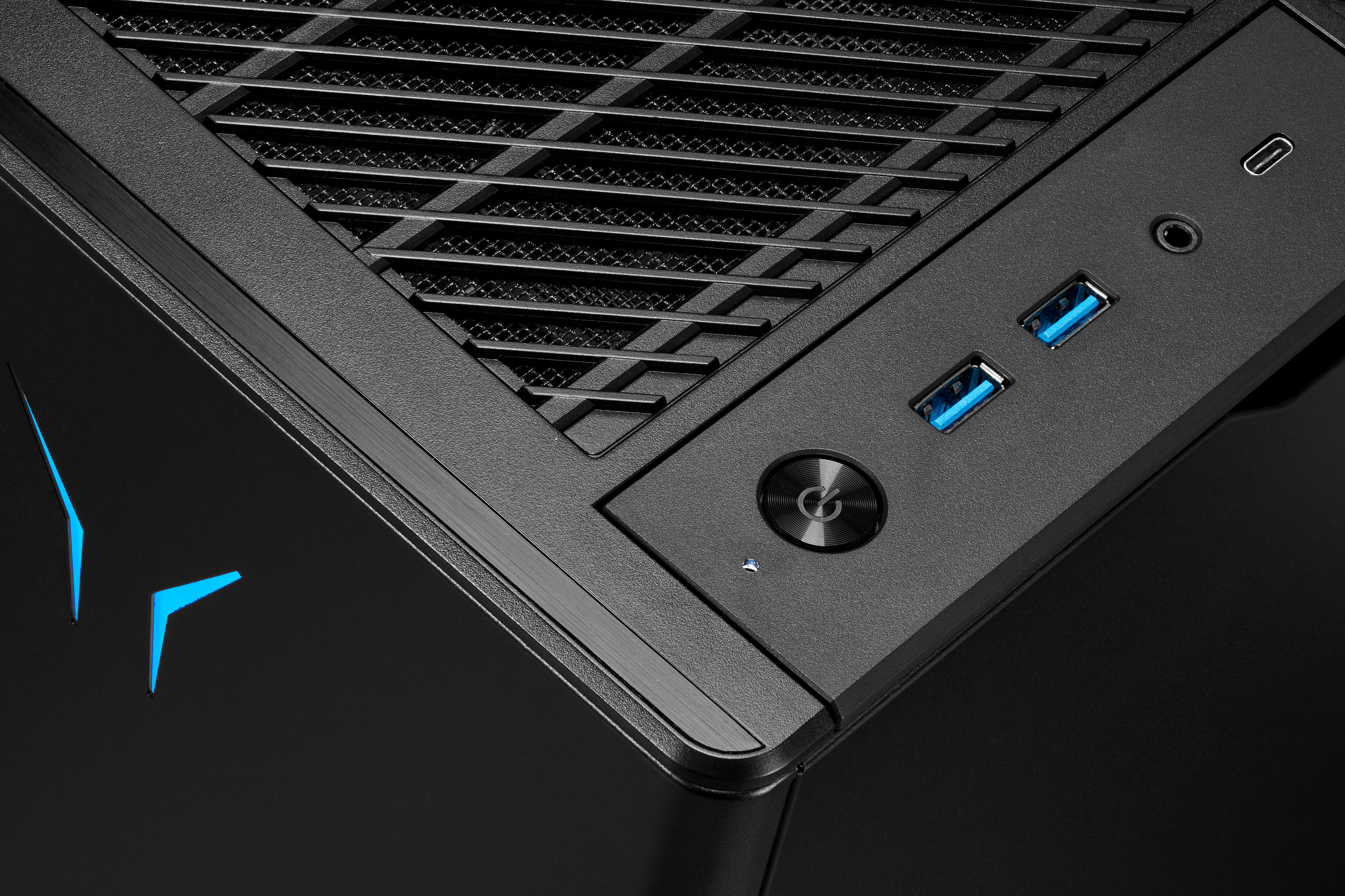 Nahaufnahme eines schwarzen Computergehäuses mit blauen Lichtern und USB-Anschlüssen.