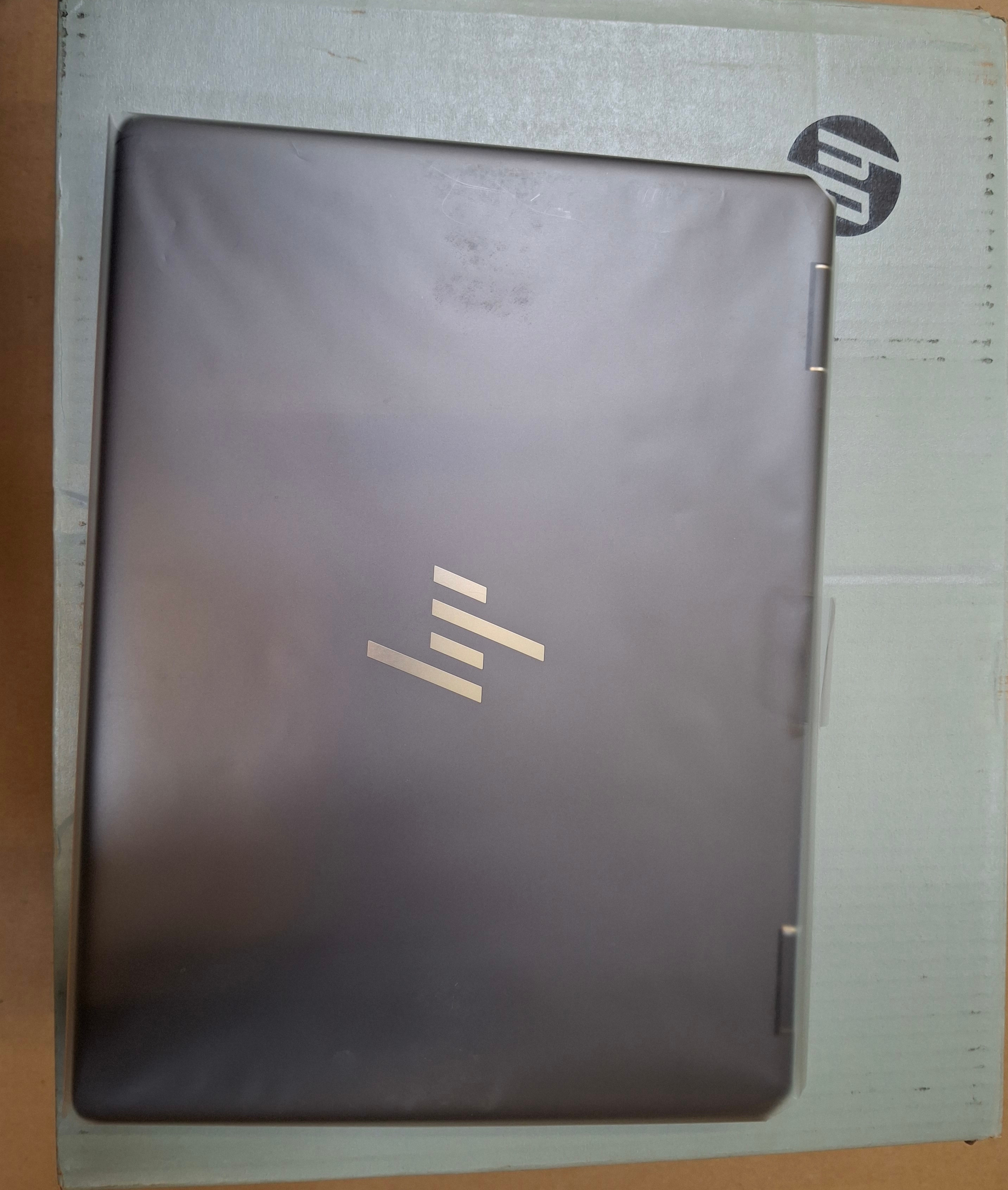 Zamknięty czarny laptop na pudełku. Widoczne logo HP.