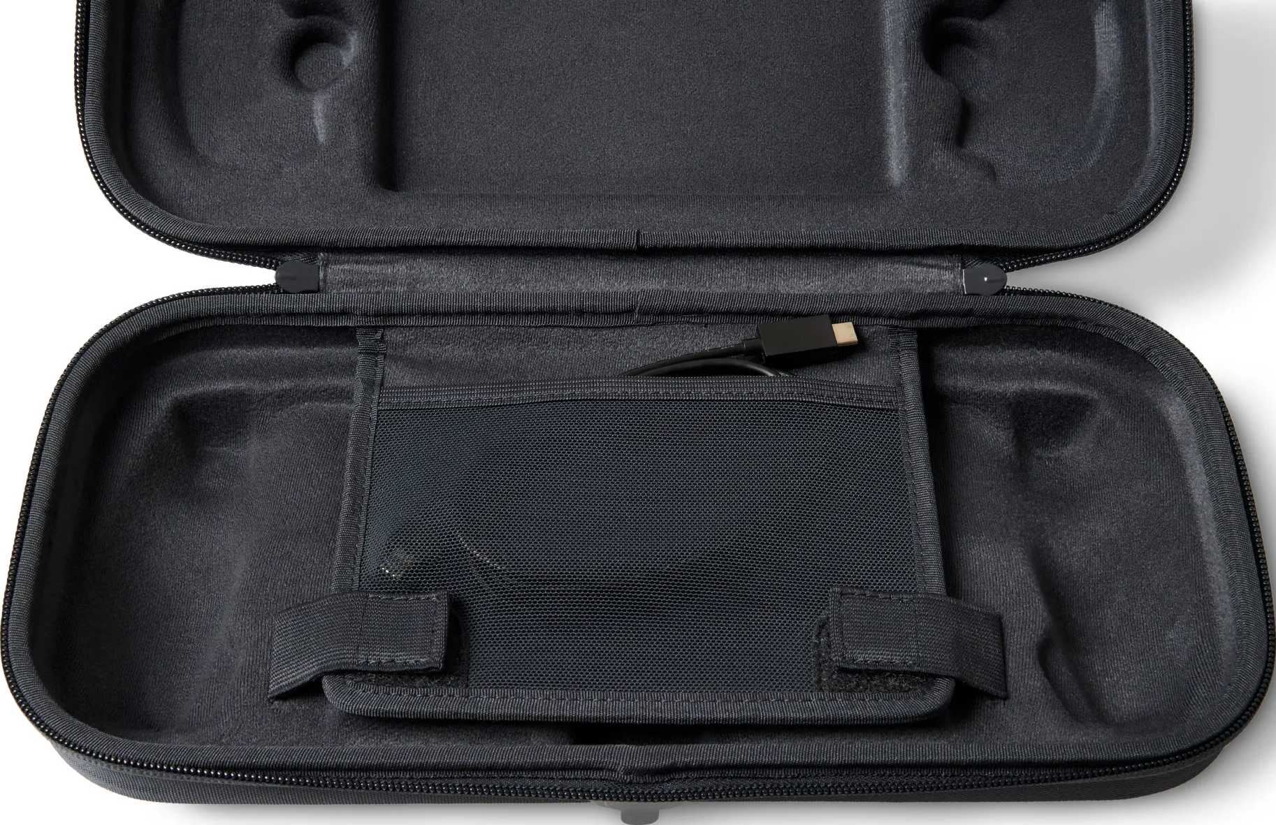 Étui noir ouvert, avec poche en filet noire et câble de chargement.