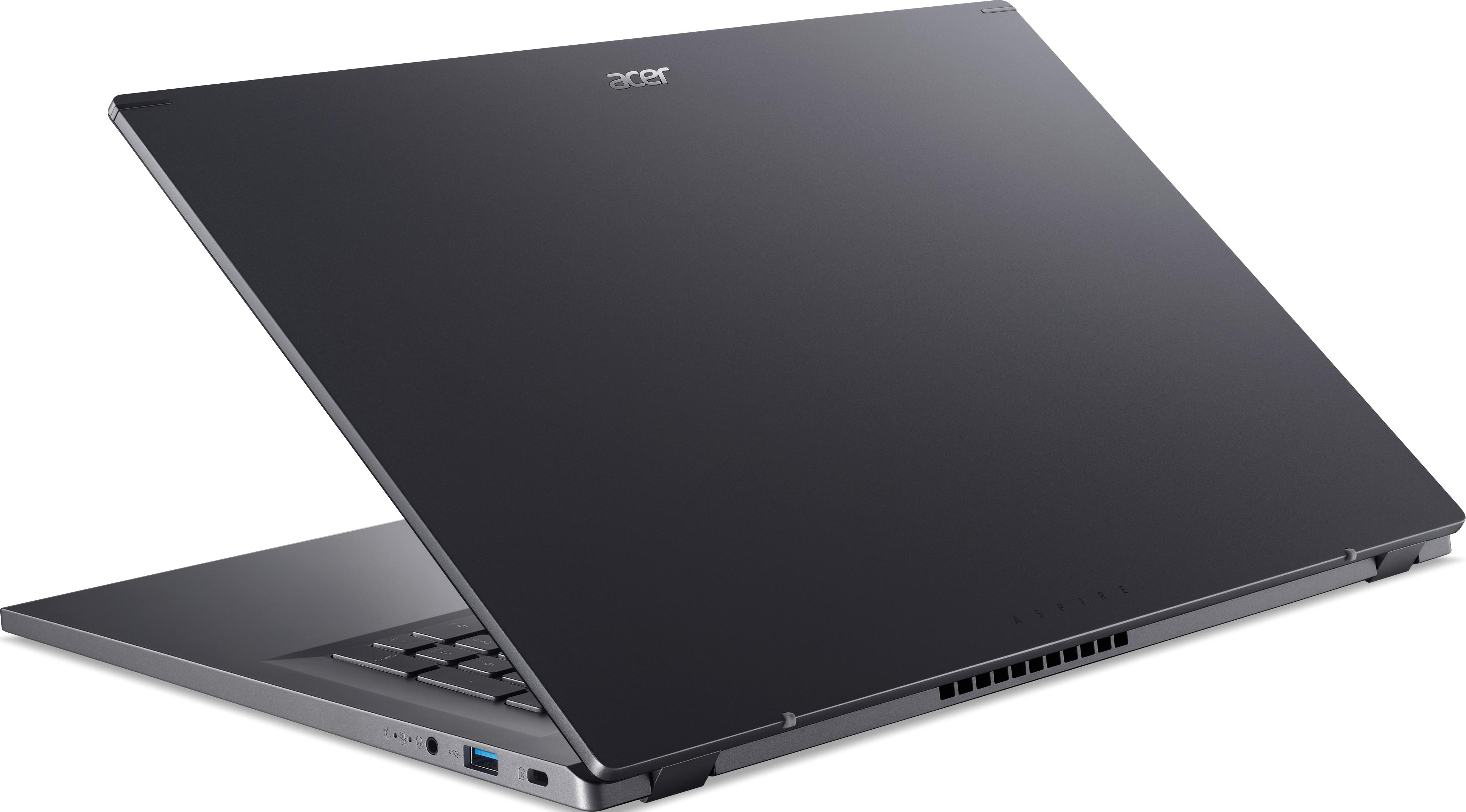 Ein Laptop mit geschlossenem, dunkelgrauem Deckel, auf einer weißen Oberfläche angewinkelt geöffnet.