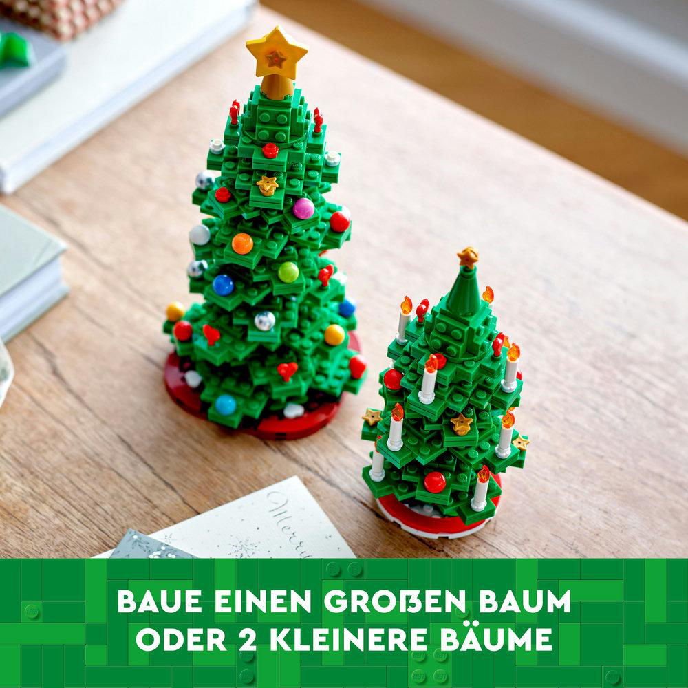 Zwei Lego-Weihnachtsbäume, einer mit Stern, auf einem Holztisch.