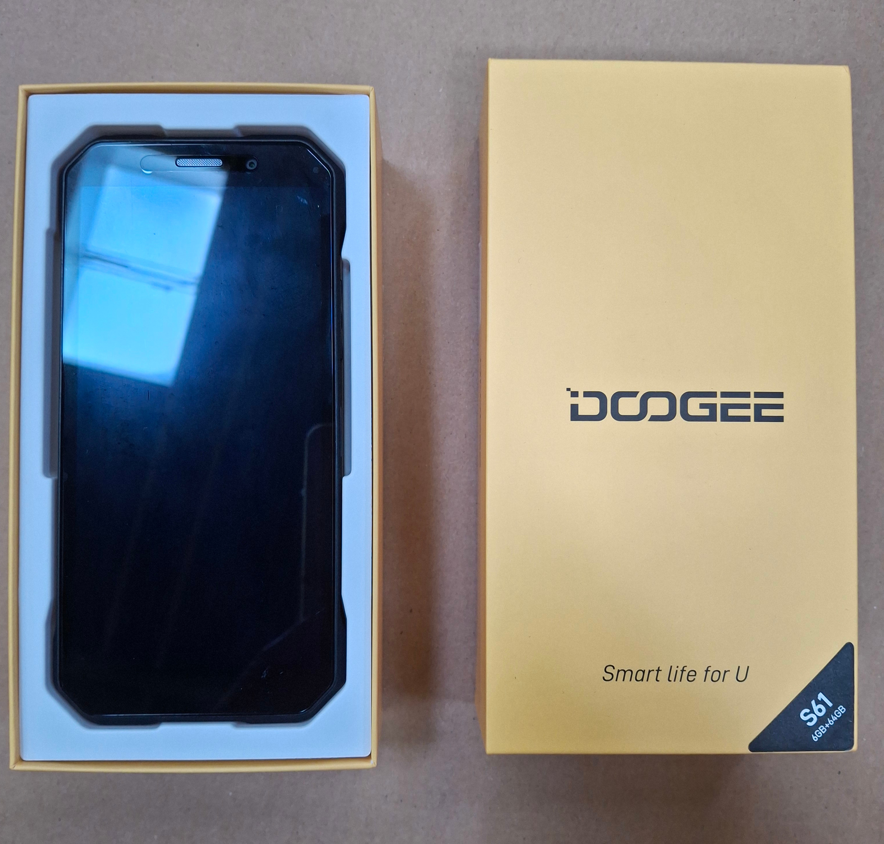 Czarny smartfon w żółtym pudełku z marką DOOGEE. Na pudełku napis: Smart life for U.
