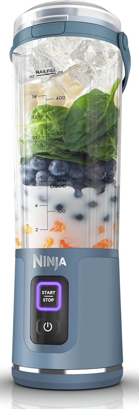 Niebieski blender ze składnikami w środku, takimi jak lód, szpinak i jagody.