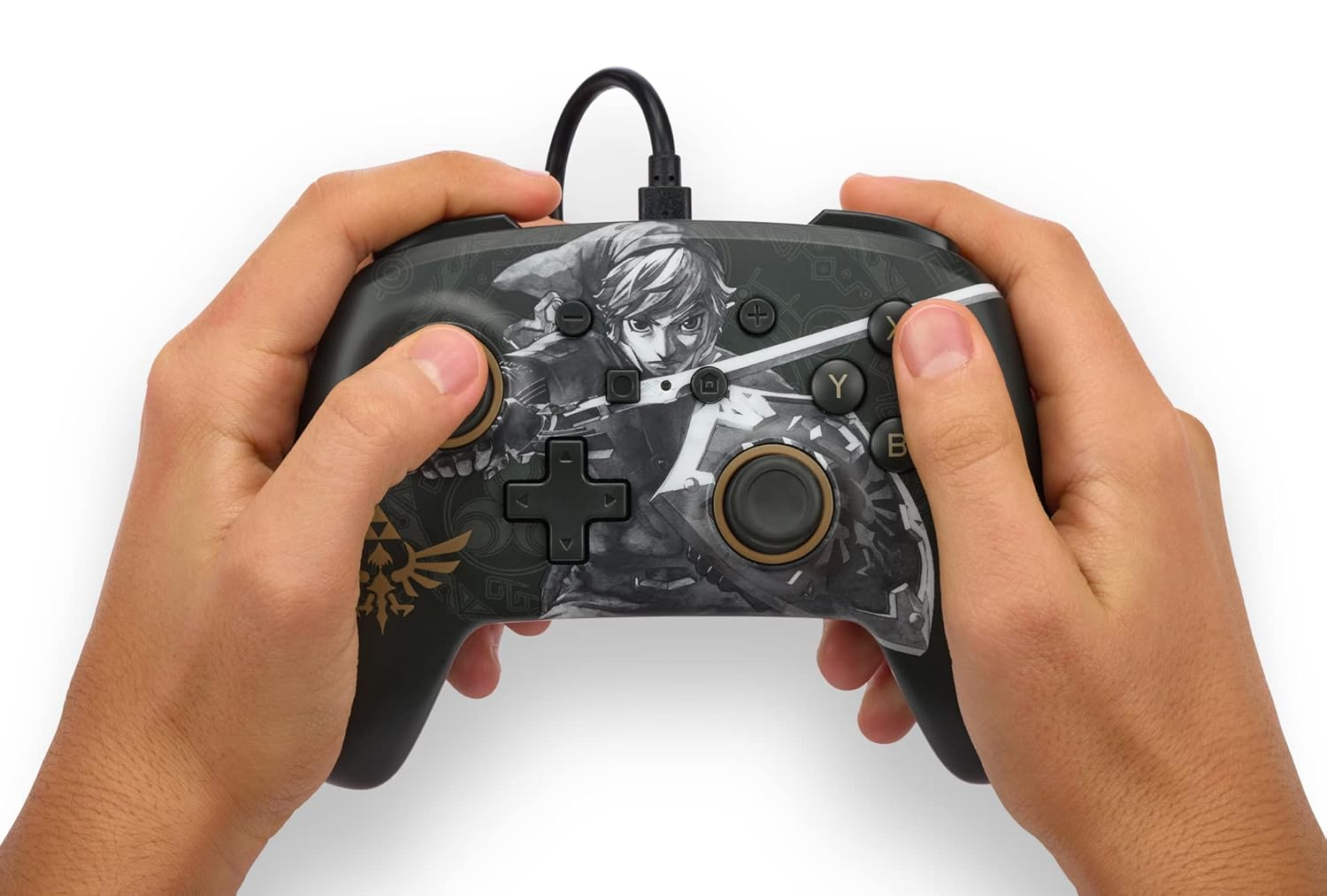 Eller, Zelda sanat eserleri, siyah kablo ve düğmeler içeren siyah bir Nintendo kontrolcüsü tutuyor.