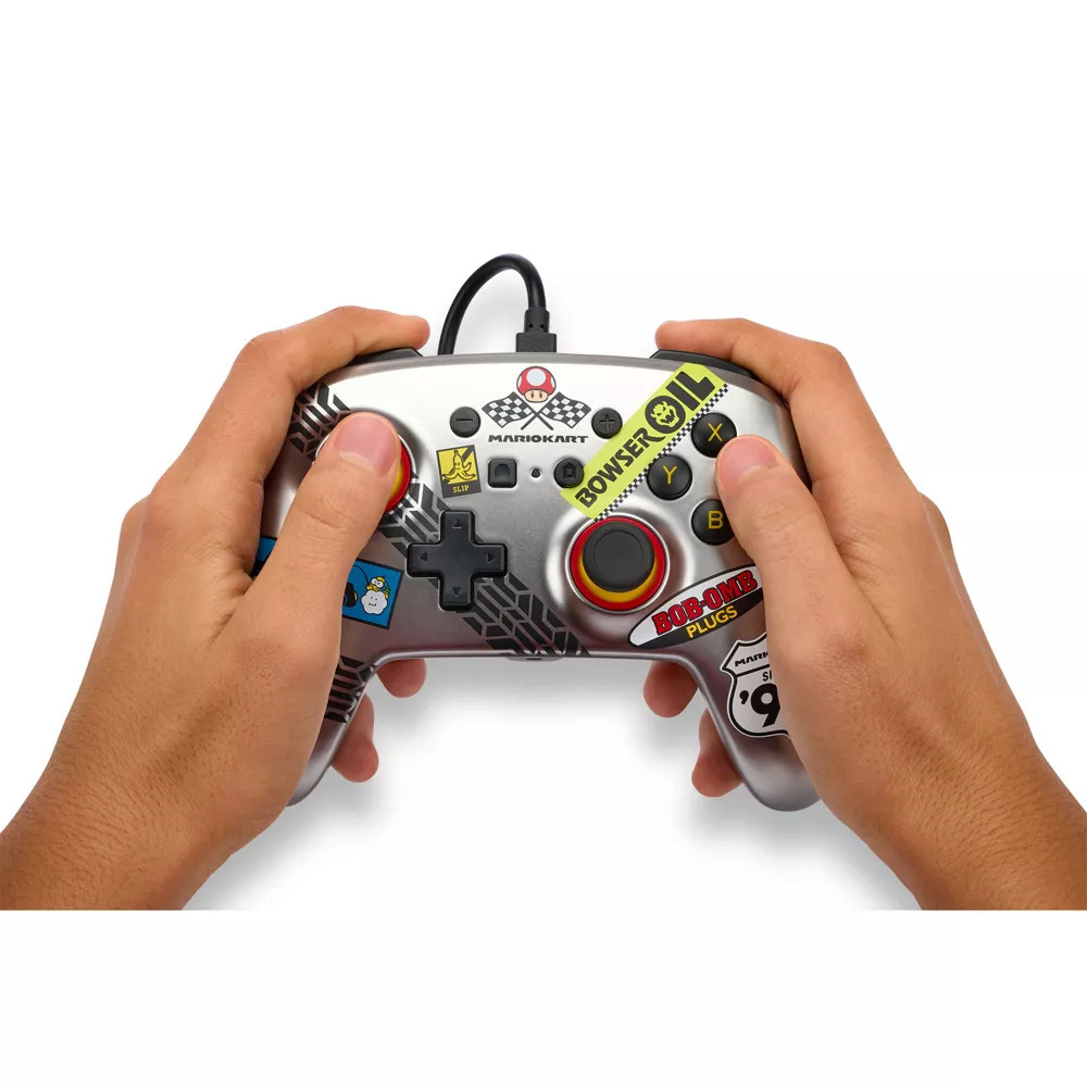 Mario Kart temalı bir oyun kumandasını tutan eller.