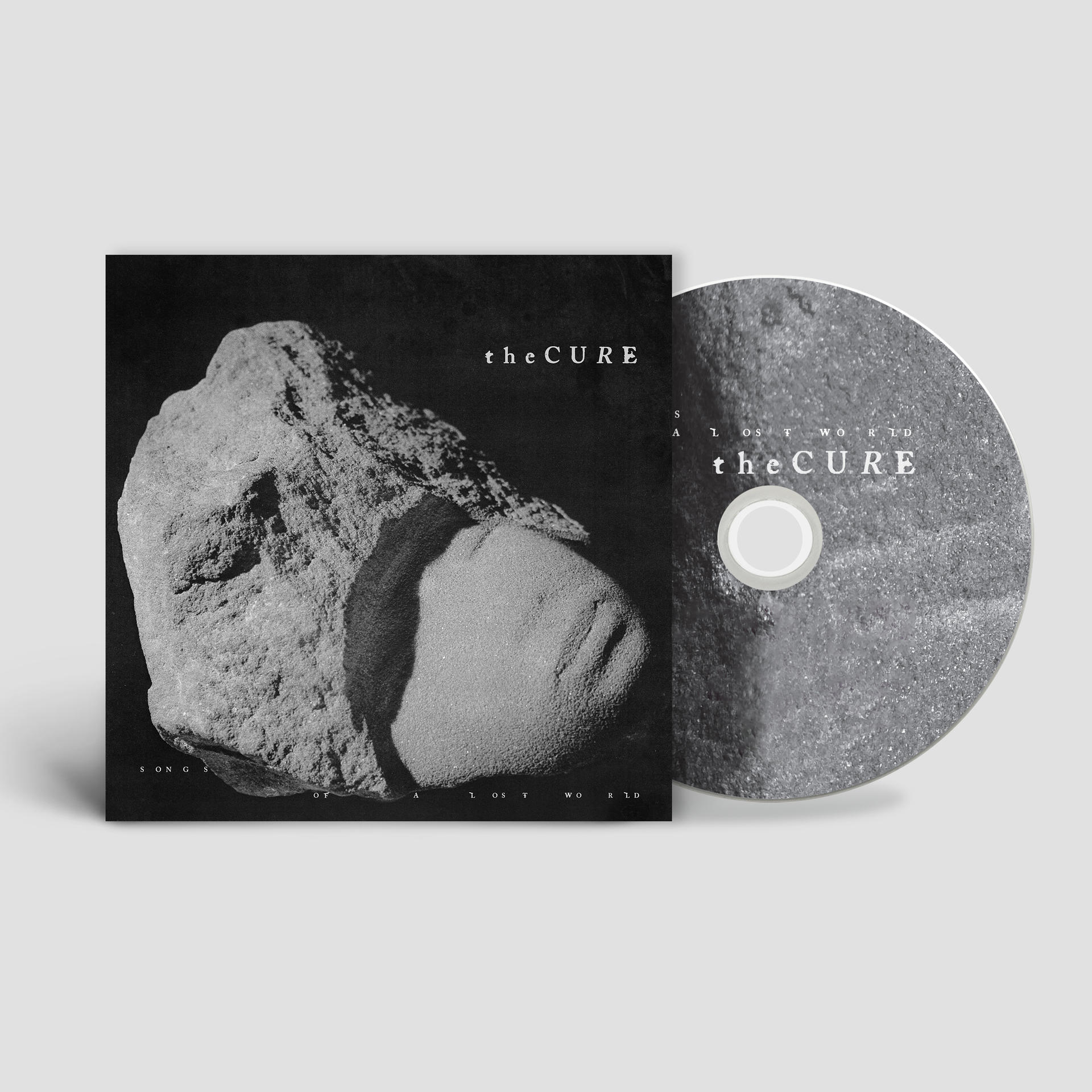 CD tok fekete-fehér képpel egy szikláról és a 'The Cure' együttes nevével.