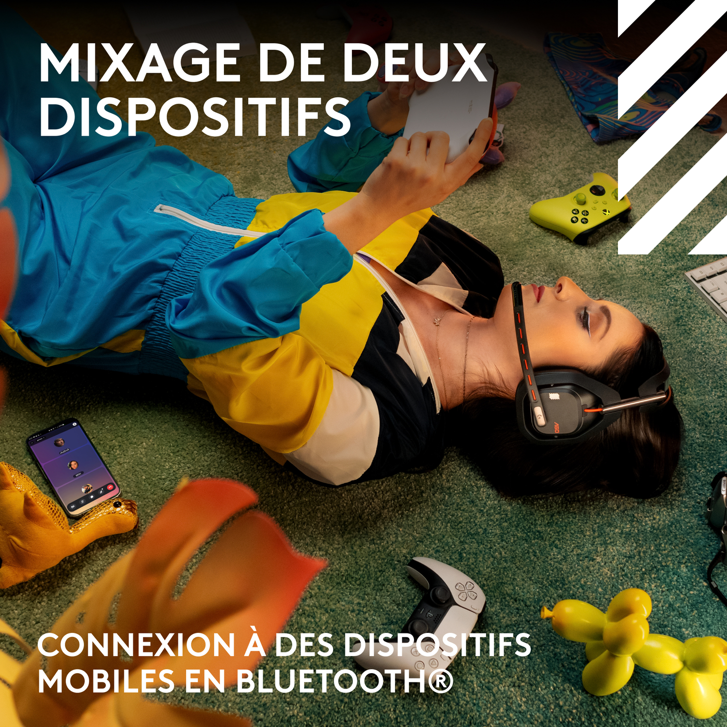 Une femme avec un casque, entourée de jouets, utilisant un téléphone et une manette.