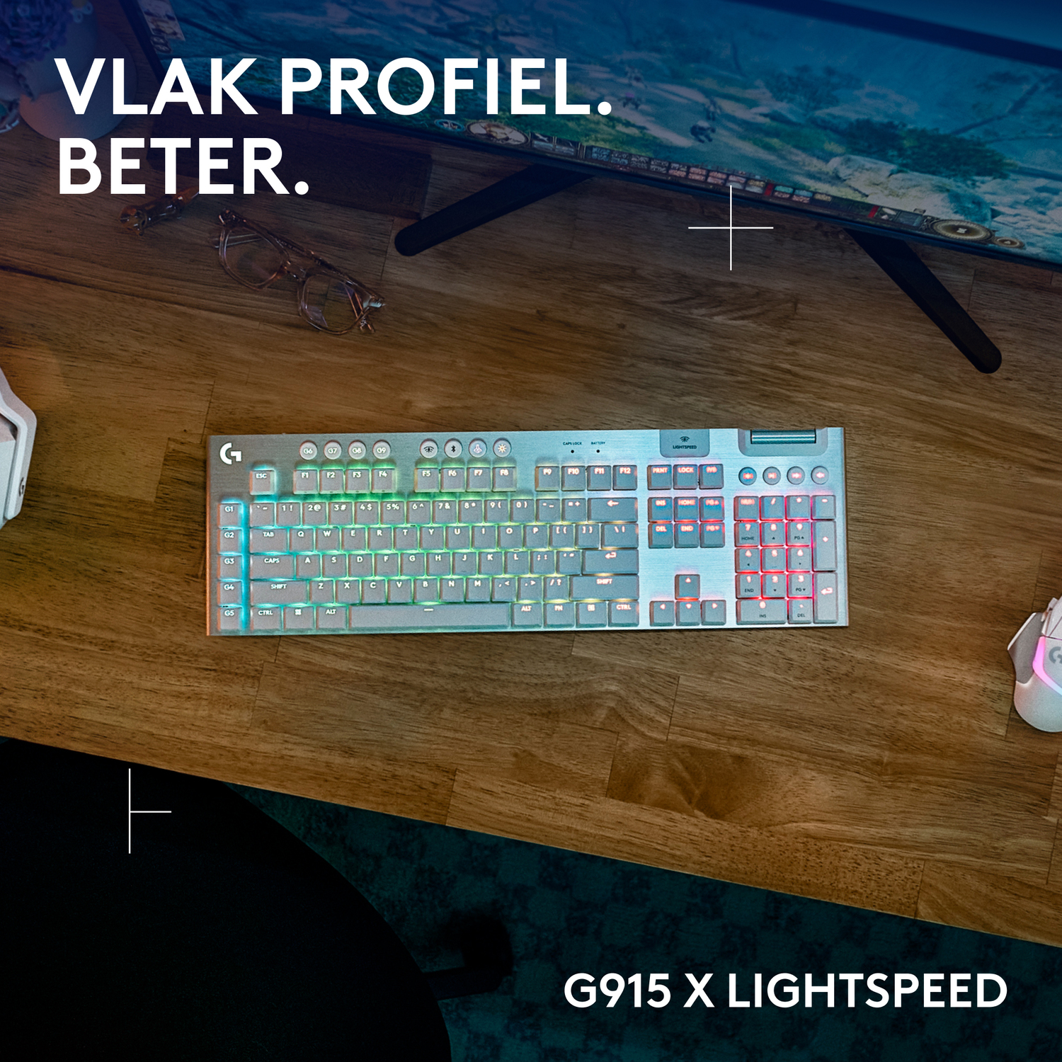 A backlit keyboard and mouse on a wooden desk. Text reads "VLAK PROFIEL. BETER. G915 X LIGHTSPEED".