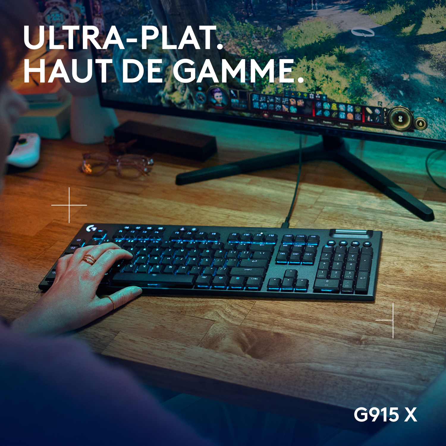 Personne utilisant un clavier et un moniteur, avec le texte G915 X en bas.