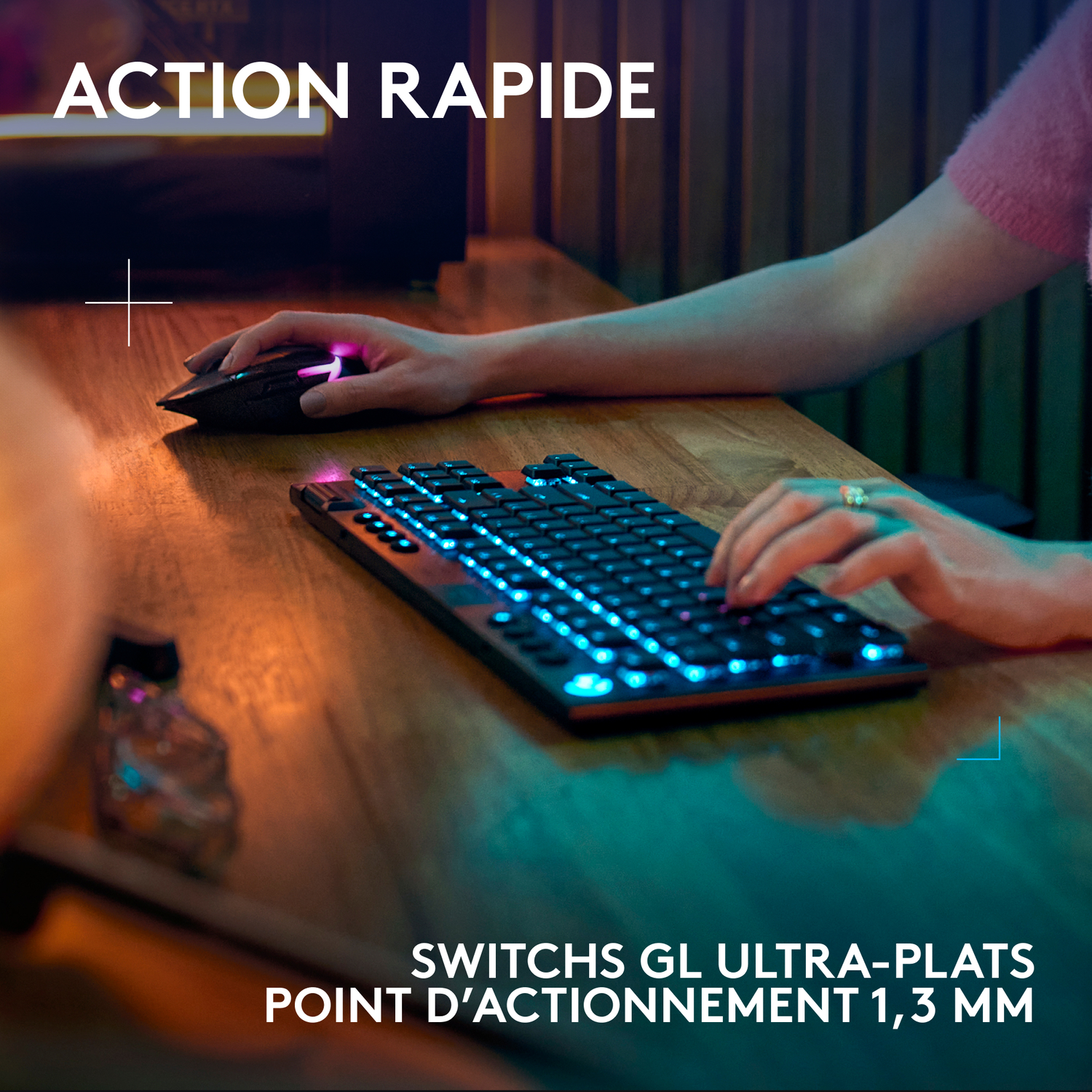 Mains utilisant un clavier avec lumières bleues et une souris sur un bureau en bois. Texte : ACTION RAPIDE.