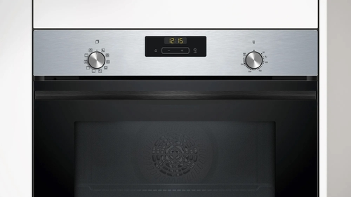Panel de control del horno con pantalla digital y perillas. La puerta del horno está cerrada.