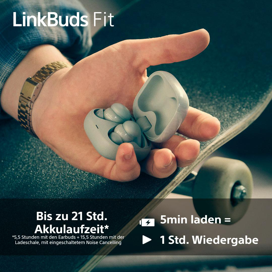 Ein Lautsprecher auf einem Tisch, eine Person hält das Ohrhörer-Case.