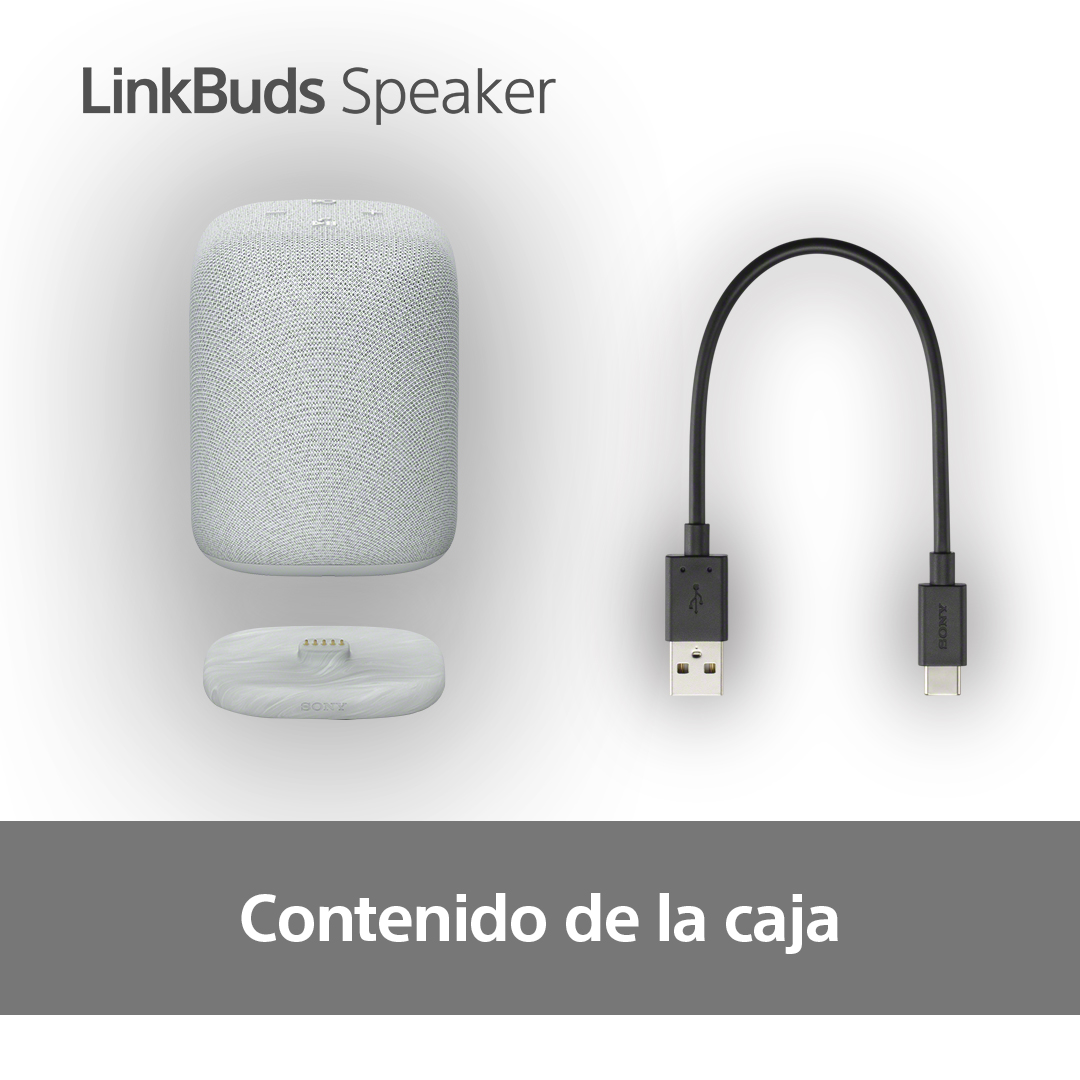Un altavoz, una base de carga y un cable USB-C están sobre una superficie blanca.