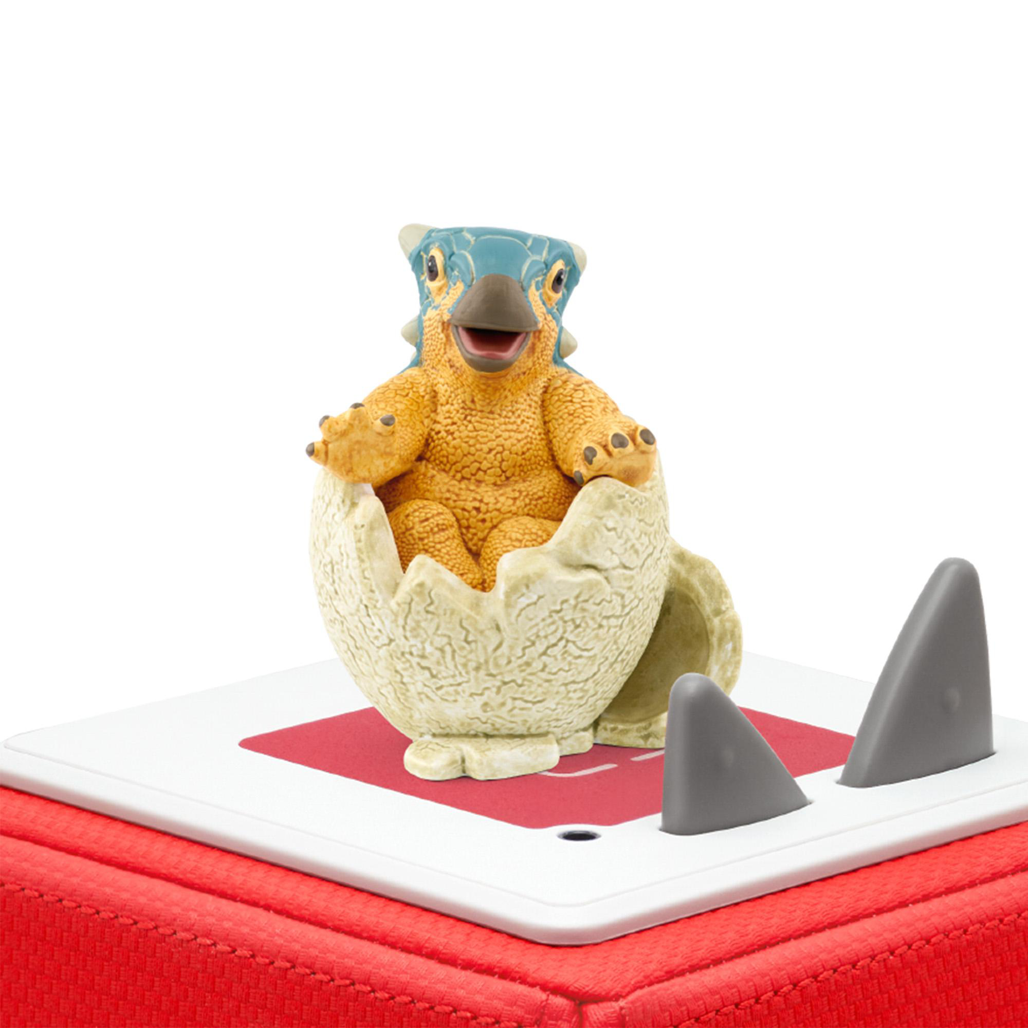 Dinosaurierspielzeug, das aus einem Ei auf einer rot-weißen Oberfläche schlüpft.