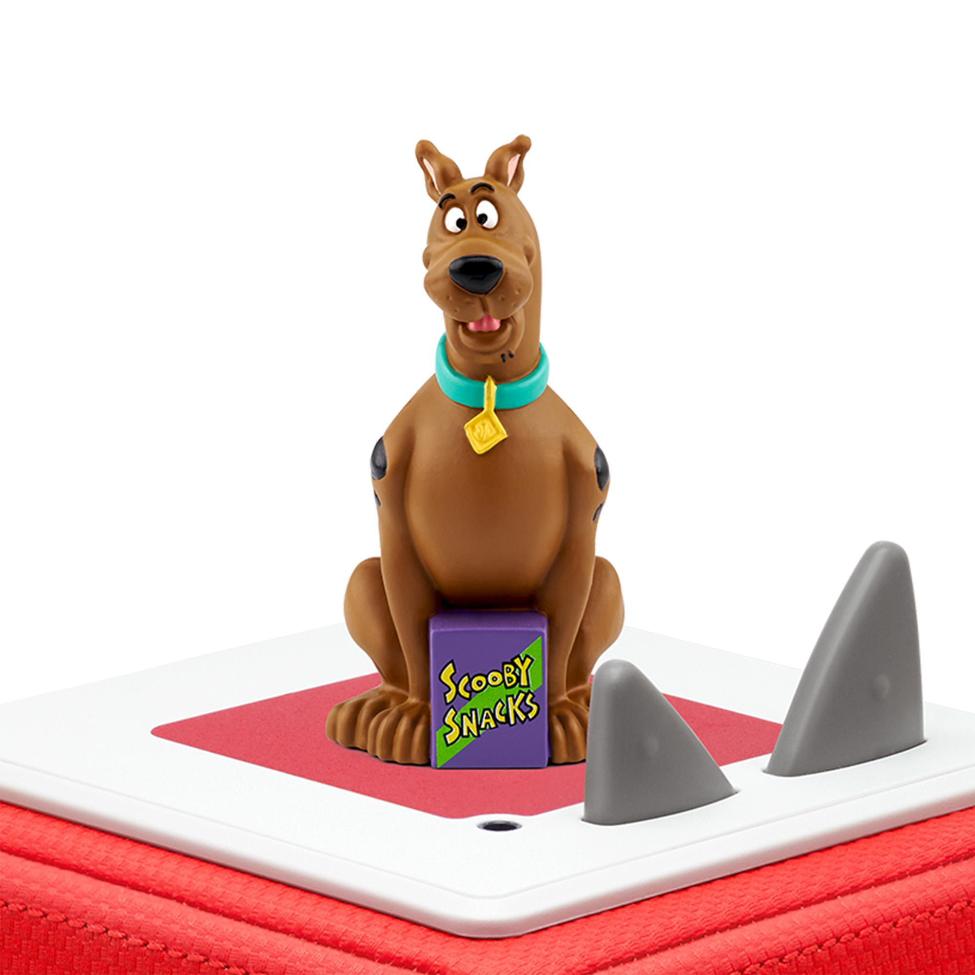 Scooby-Doo-Spielzeugfigur sitzt auf einem rot-weißen Würfel mit Haifischflossen-Ausschnitten.