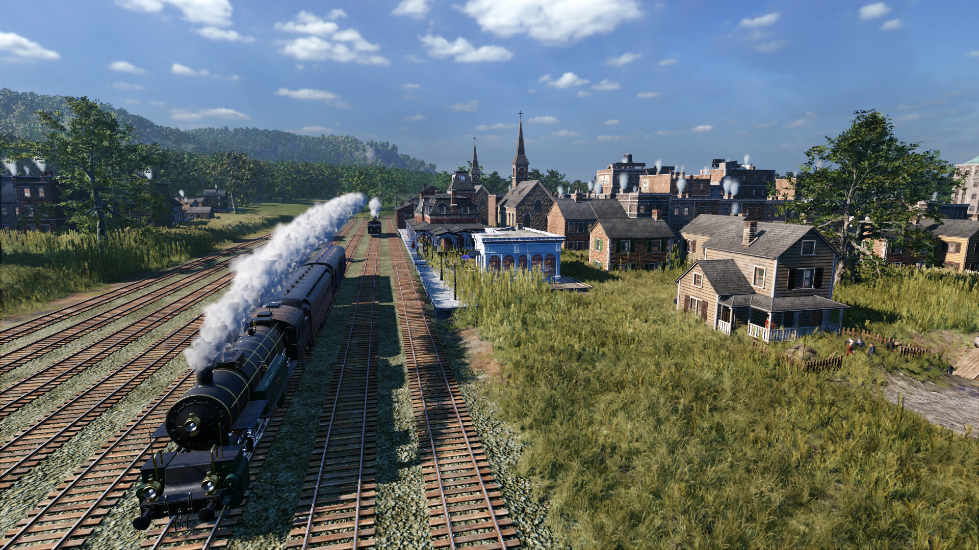 Zug auf Gleisen in einer Stadt mit Häusern. Dampf kommt aus dem Zug. Grünes Gras und blauer Himmel.