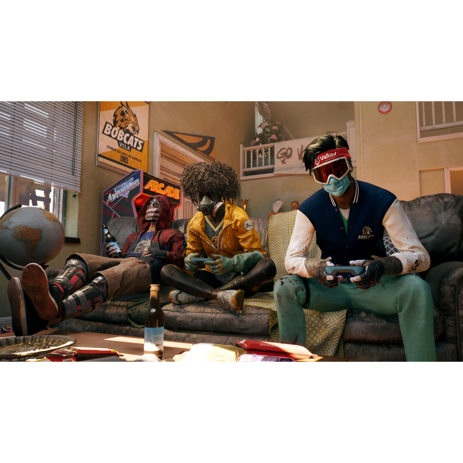 Drie mensen spelen videogames op een bank. Eén persoon draagt een masker en vizier.