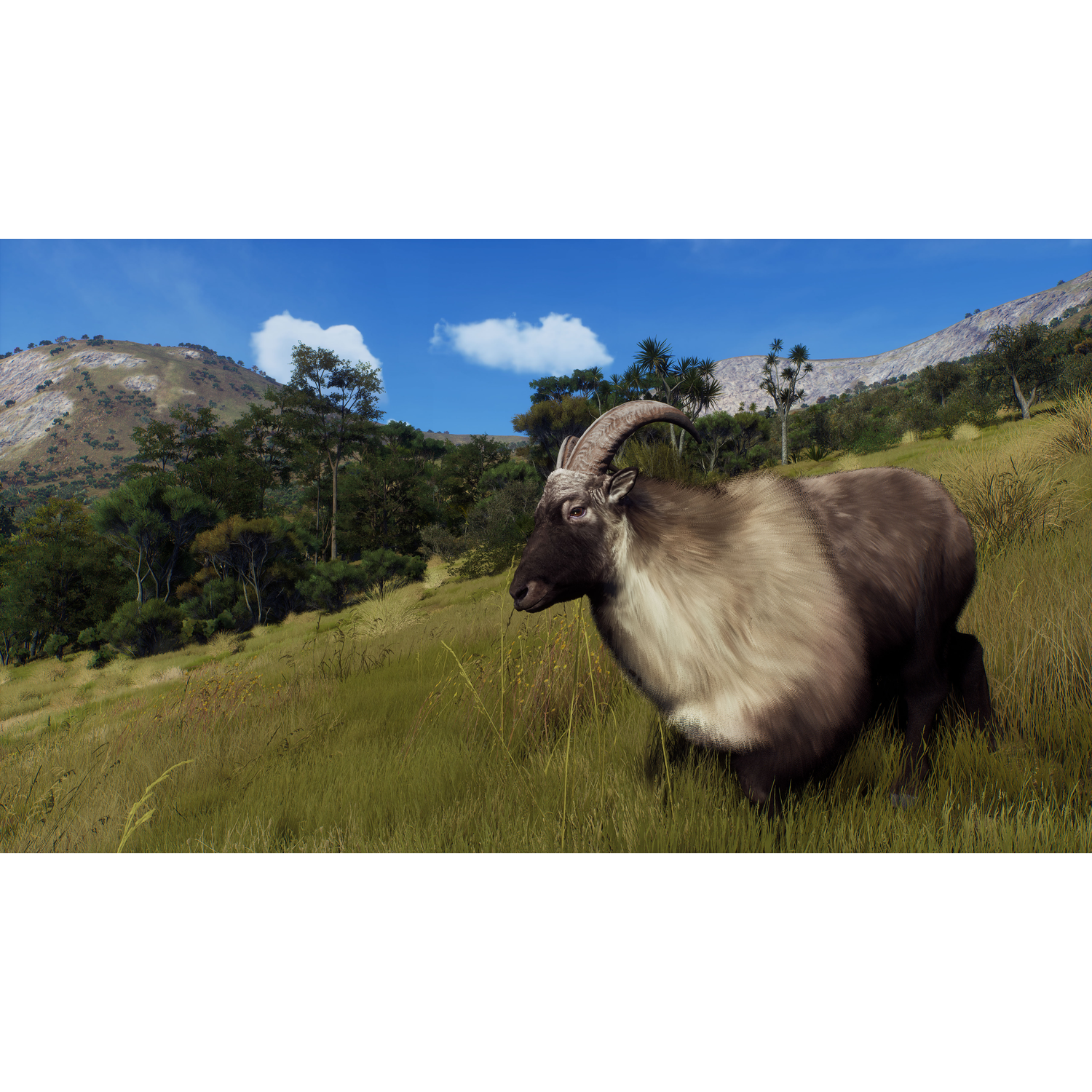 Een Himalaya Tahr in een grasveld met bomen en bergen op de achtergrond, onder een blauwe lucht.