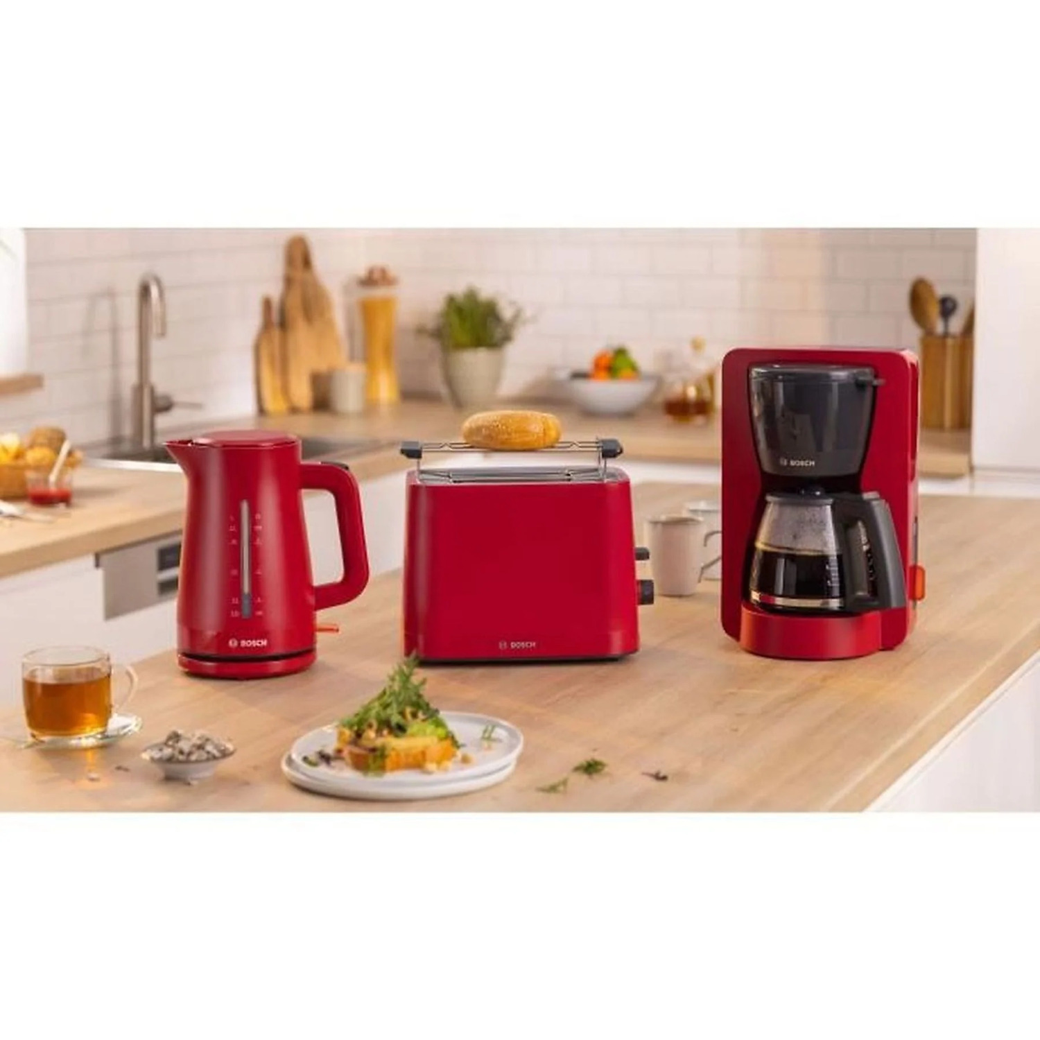 Rode Bosch keukenapparaten: waterkoker, broodrooster met brood en koffiezetapparaat.